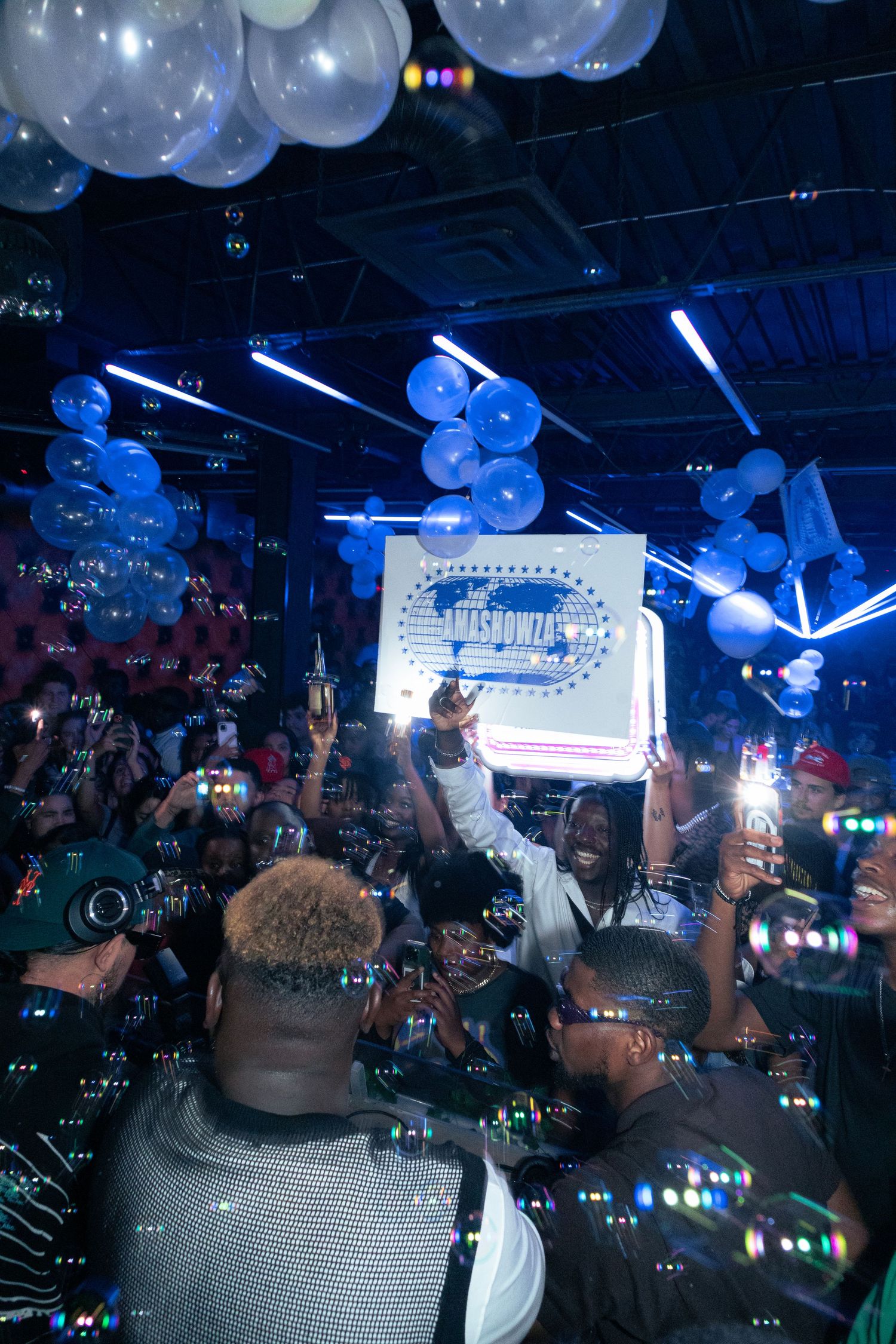 Nightclub celebration with blue balloons and lighting effects creating a festive atmosphere.