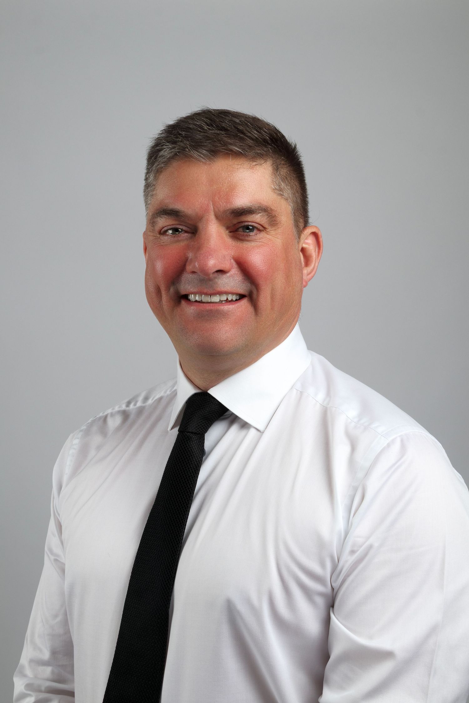 Headshot Portrait, Grey backdrop, Man smiling, Male in professional attire