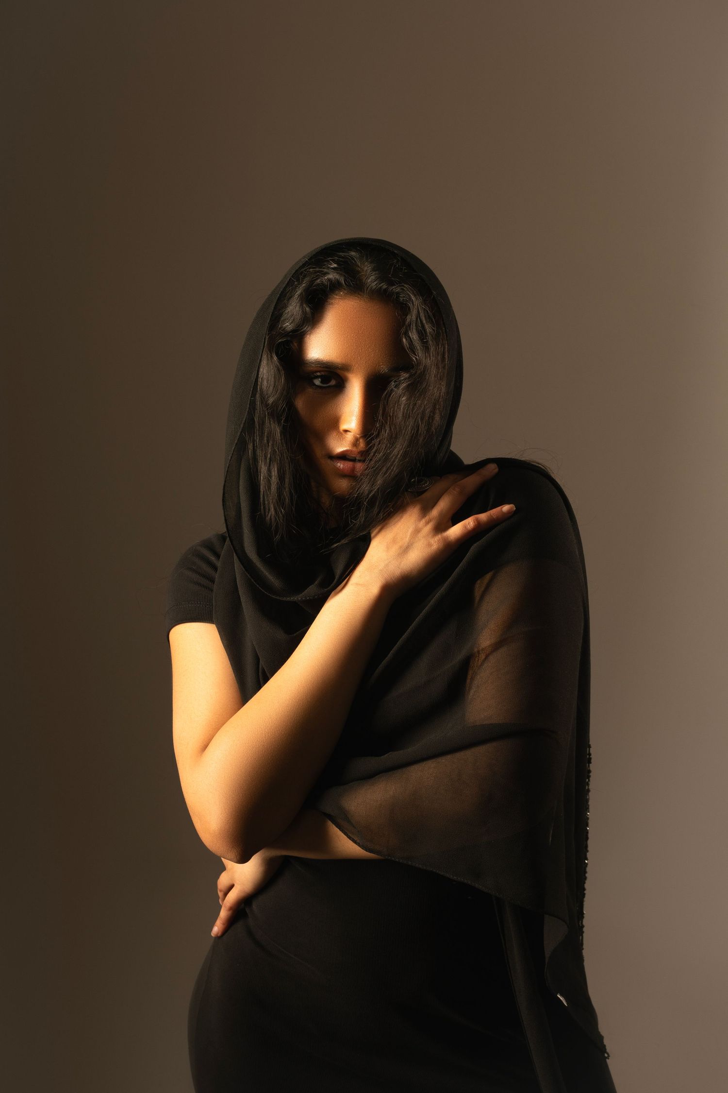 Dramatic portrait series with figure in black against moody lighting.