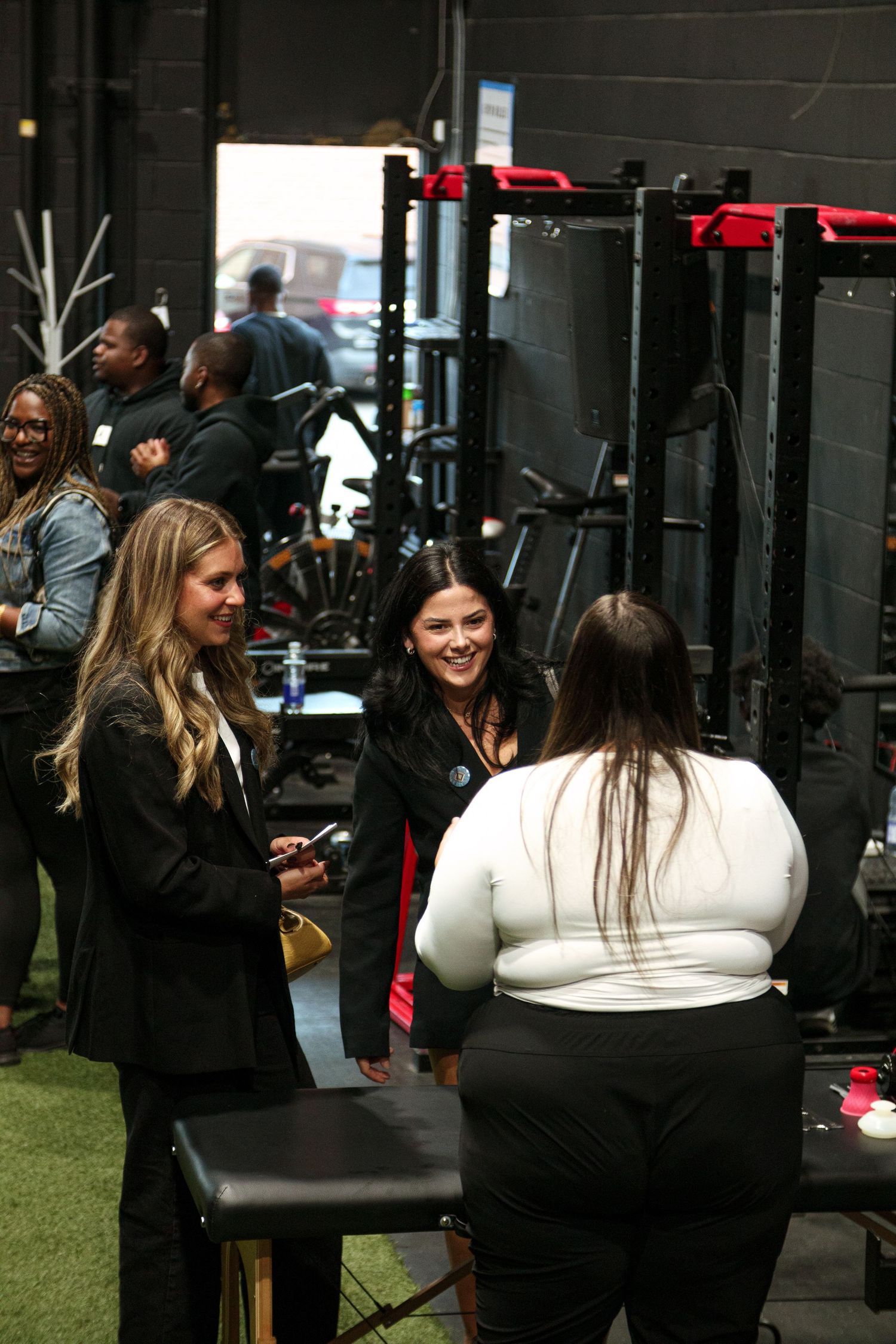 Group socializing in a dark indoor space with artificial turf flooring.