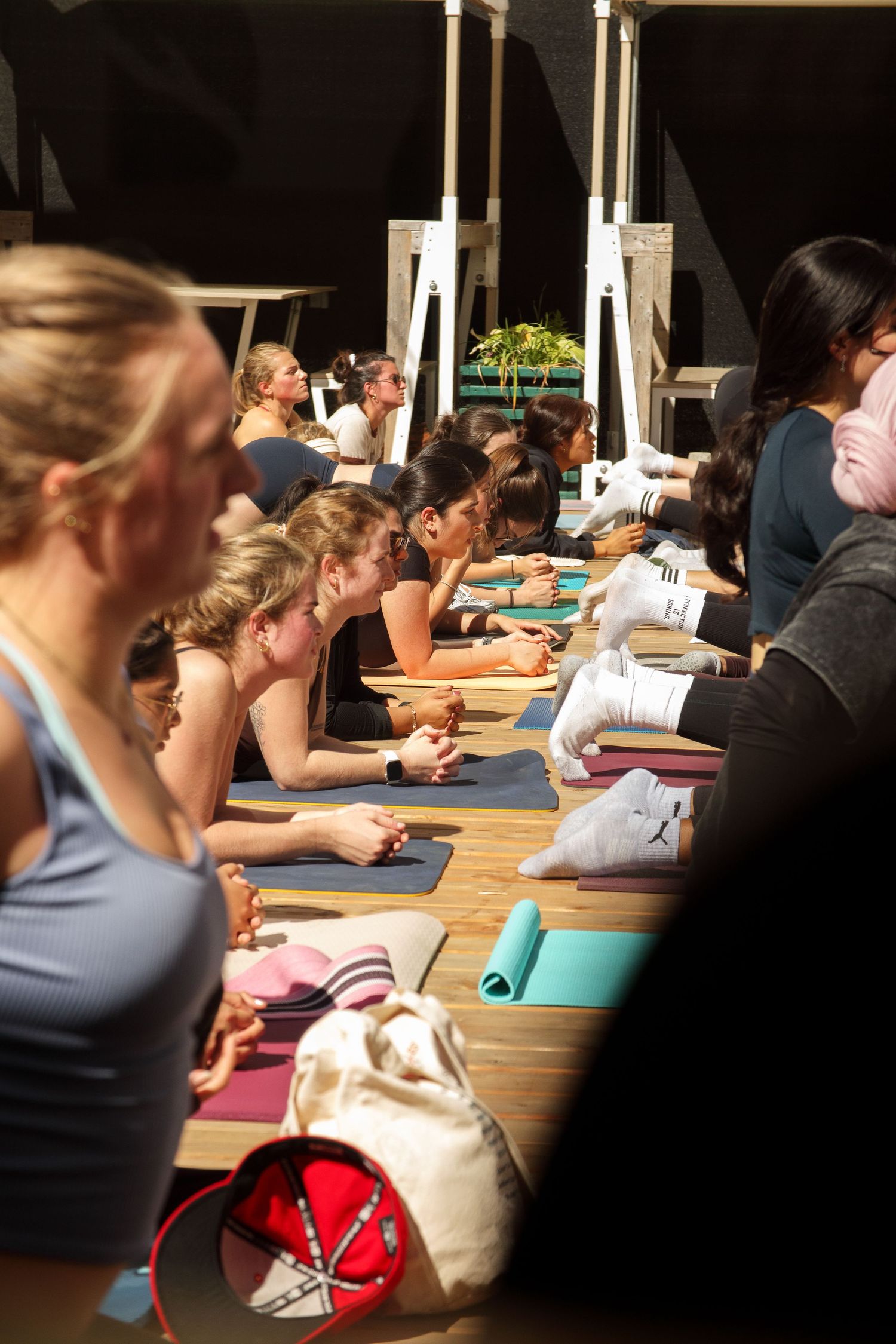 People lying on yoga mats in a studio during class.