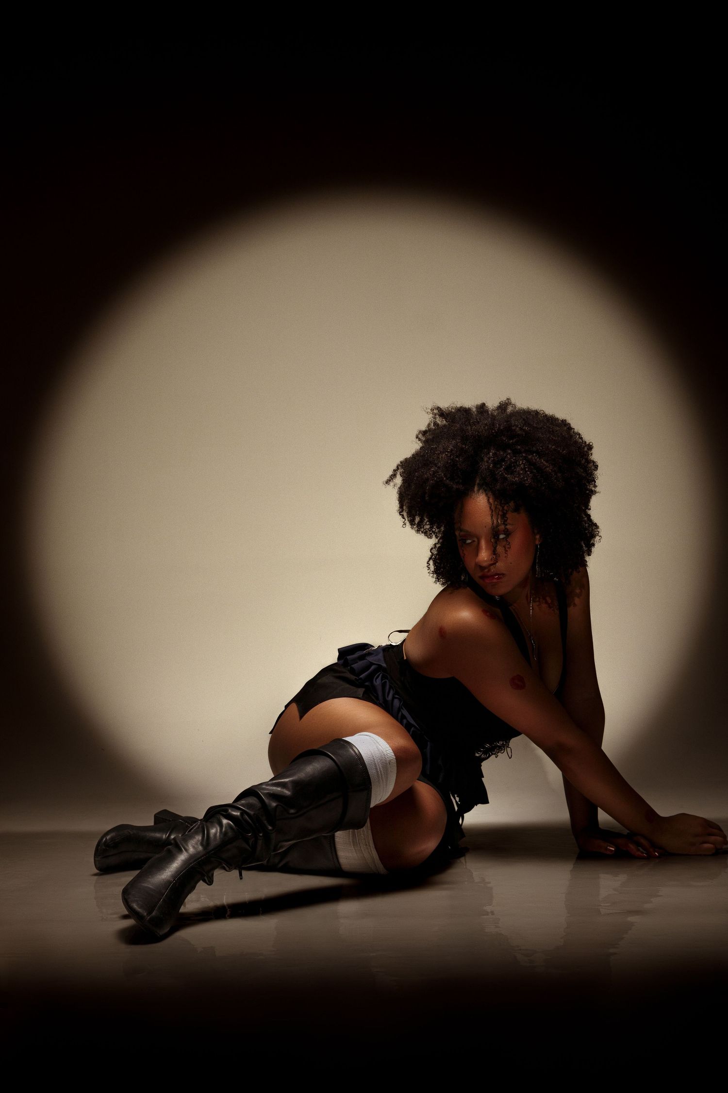 Dramatic silhouette of figure in boots lying on floor in artistic pose.