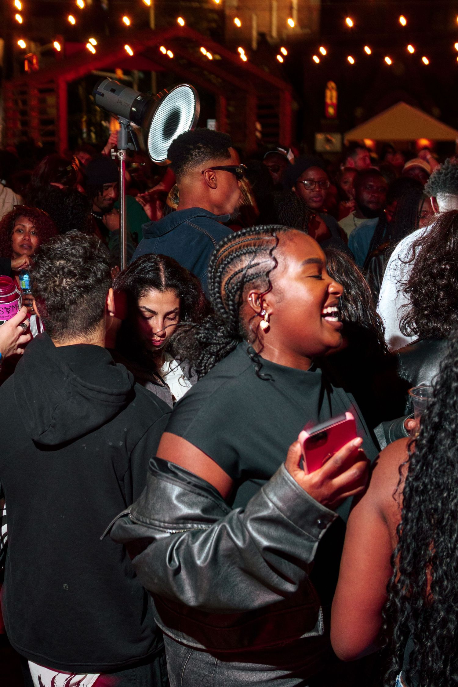 Party-goers dancing and socializing at a dimly lit nightclub event.