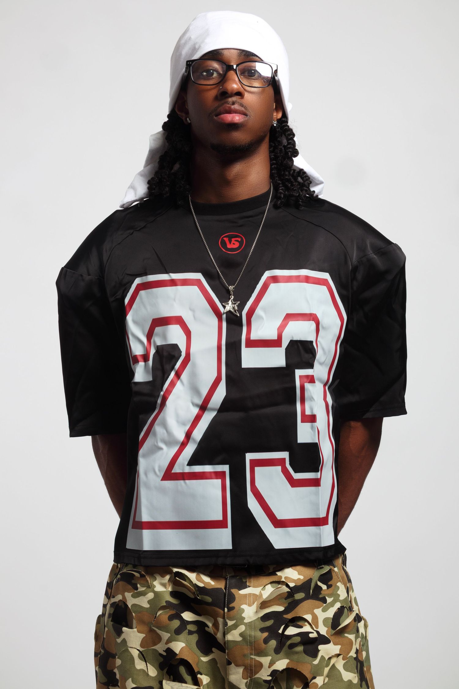 Sports-inspired photoshoot with jersey number 23 and camouflage pants.