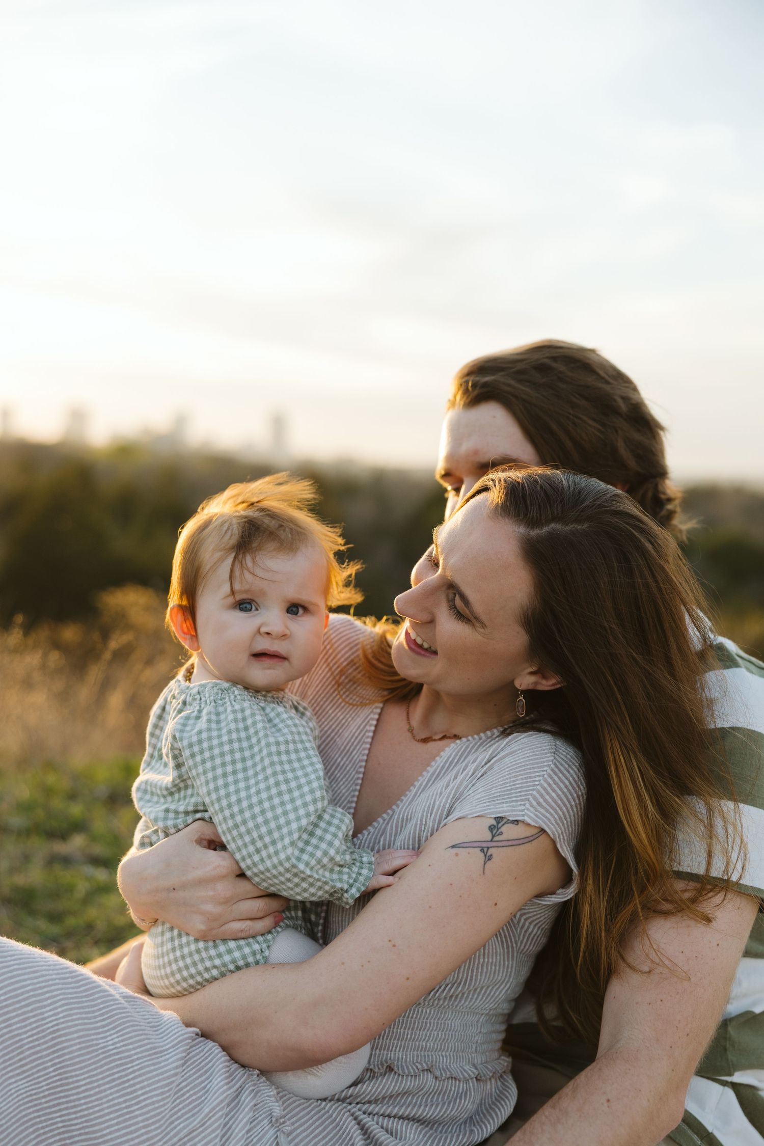 Sunset at Tandy Hills in Fort Worth surrounding a family of three during their fall family photos.