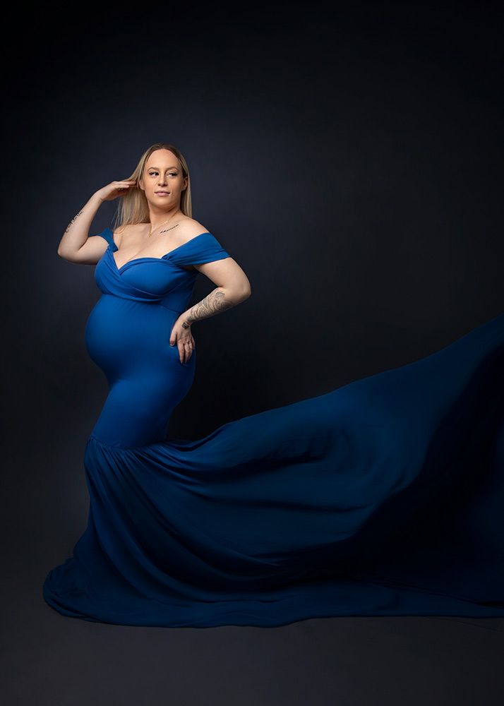 Maternity session Peterborough - beautiful pregnant woman in deep blue mermaid maternity dress with dramatic train in Spalding studio