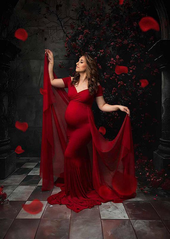 artistic maternity photoshoot Spalding red gown rose petals dramatic lighting
