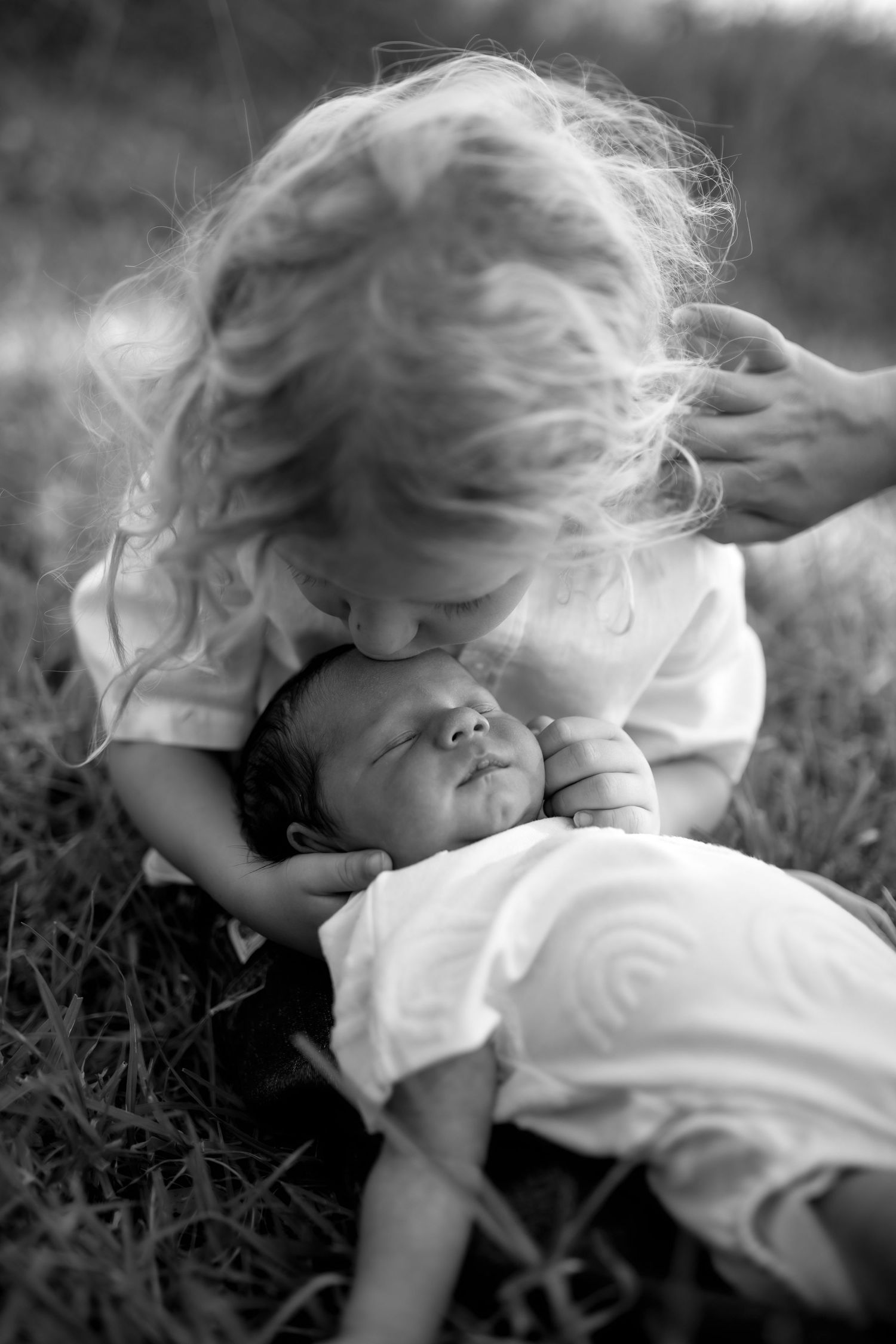 Series of black and white photos showing a child playing in grass.