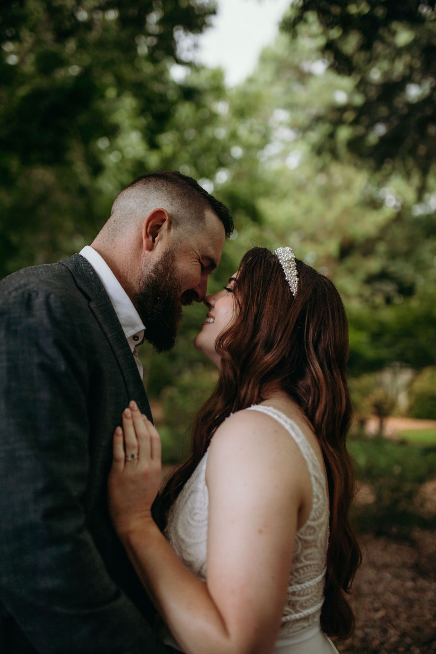 Romantic wedding couple sharing intimate moments in an outdoor garden setting.