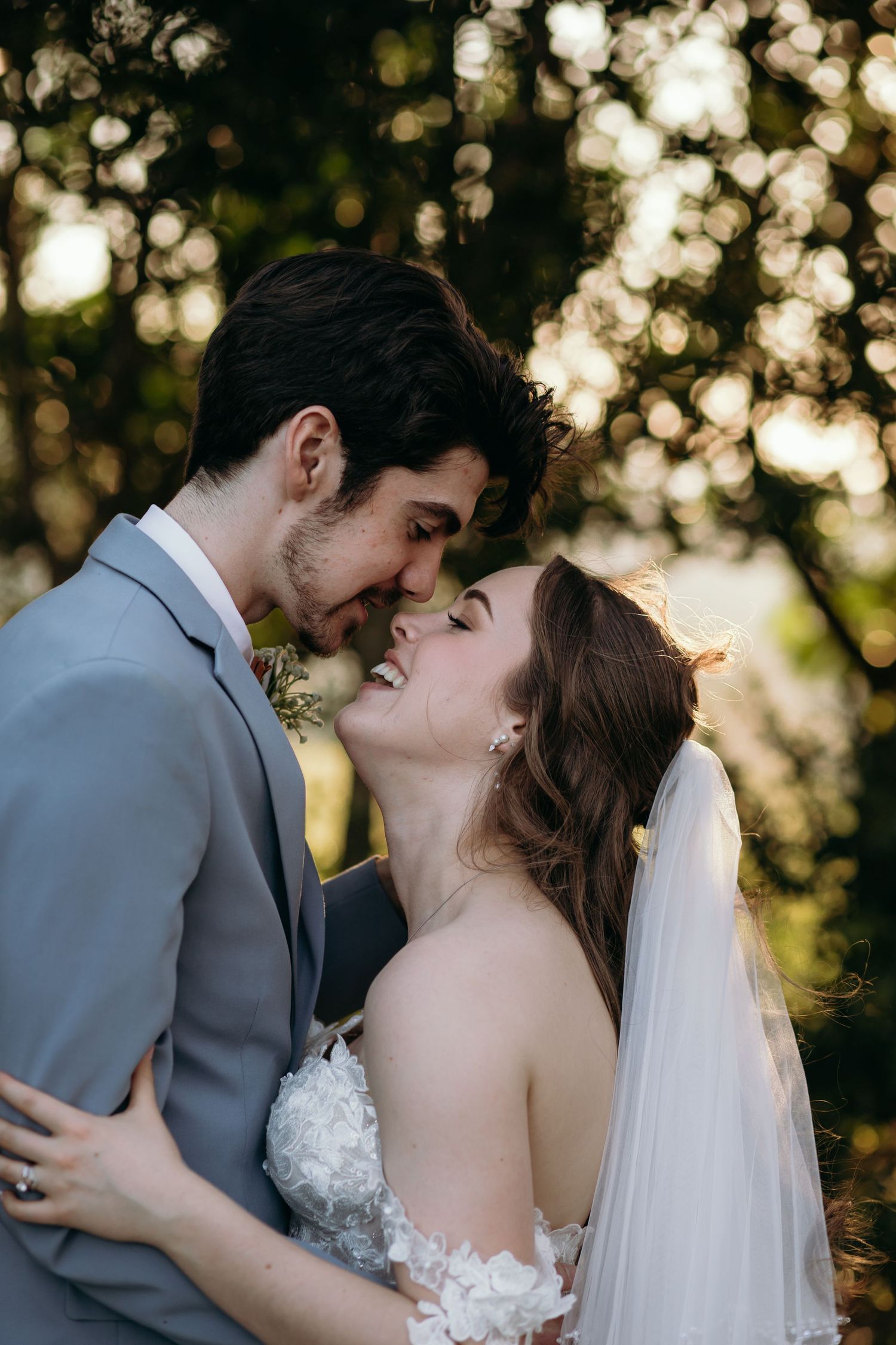 Romantic wedding couple embracing during golden hour photography session.