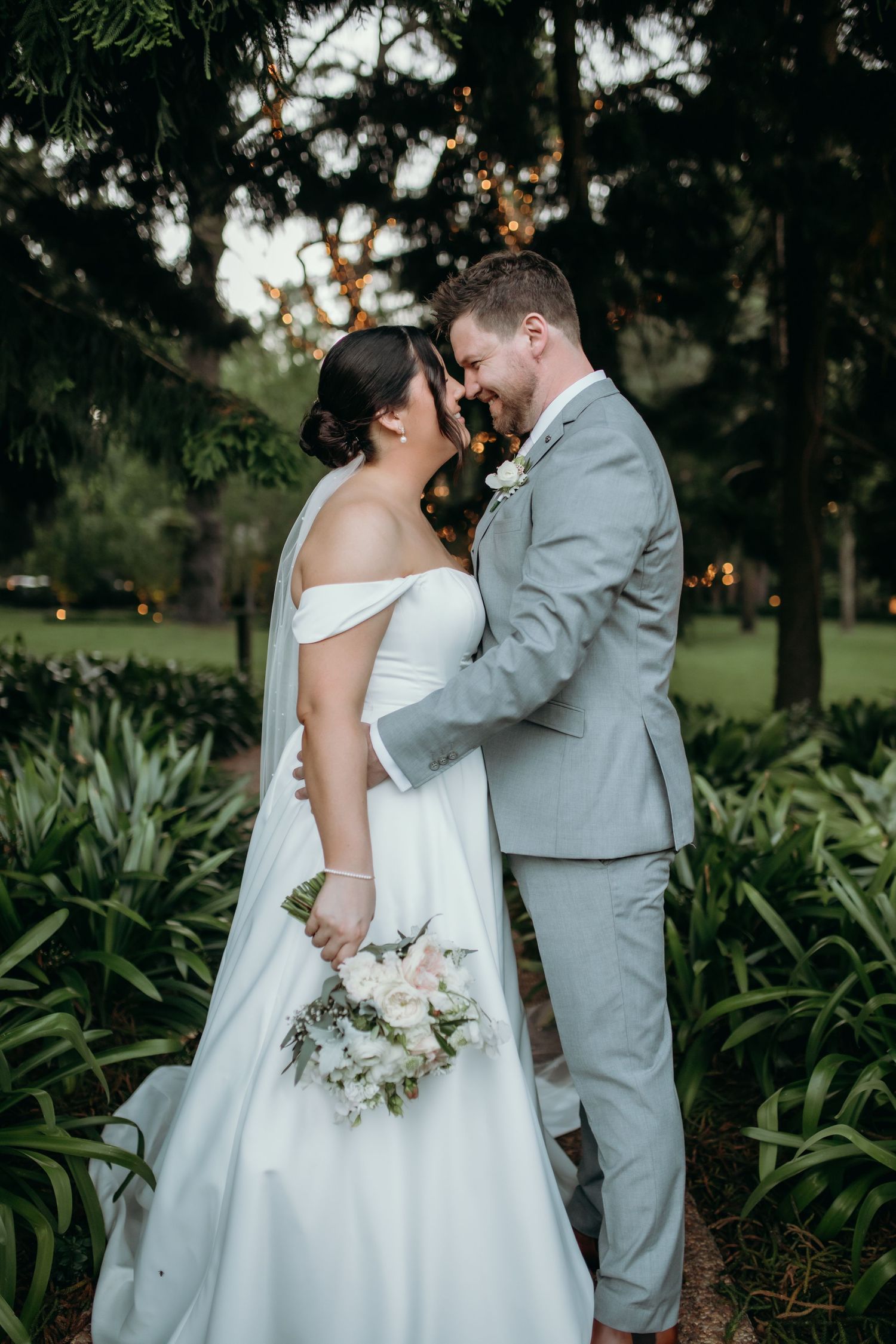 Intimate wedding couple portraits in a lush garden setting with tropical plants.