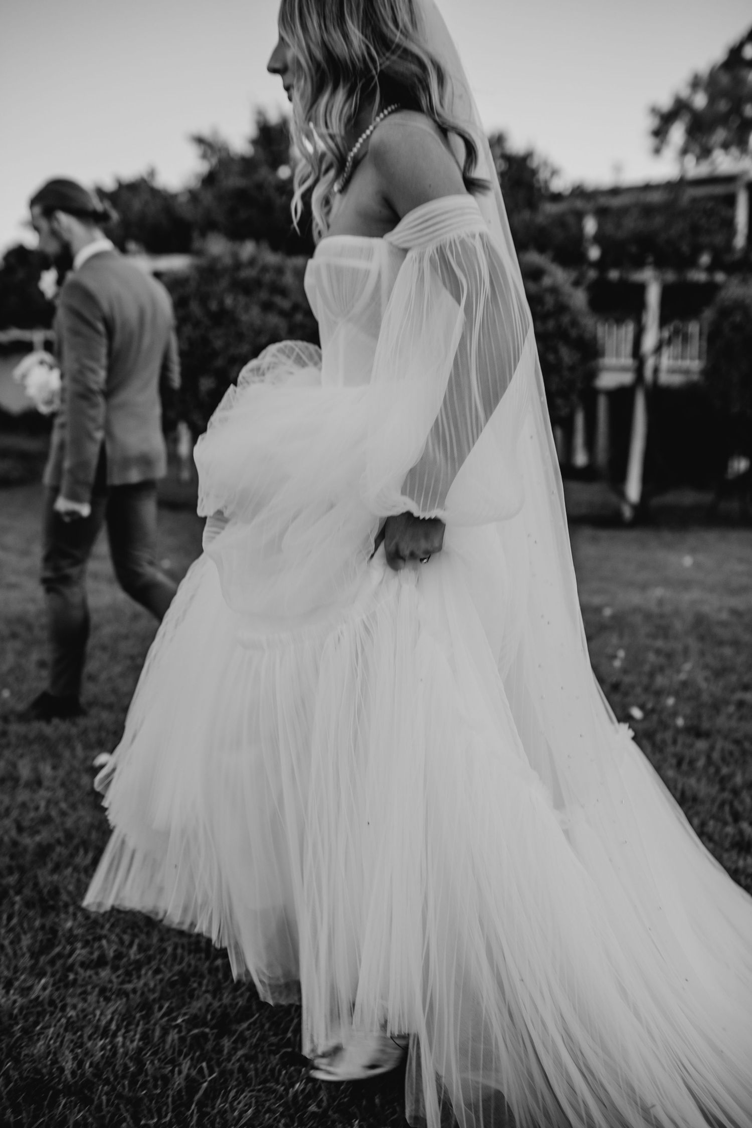 Flowing white tulle wedding dresses captured in black and white photography.