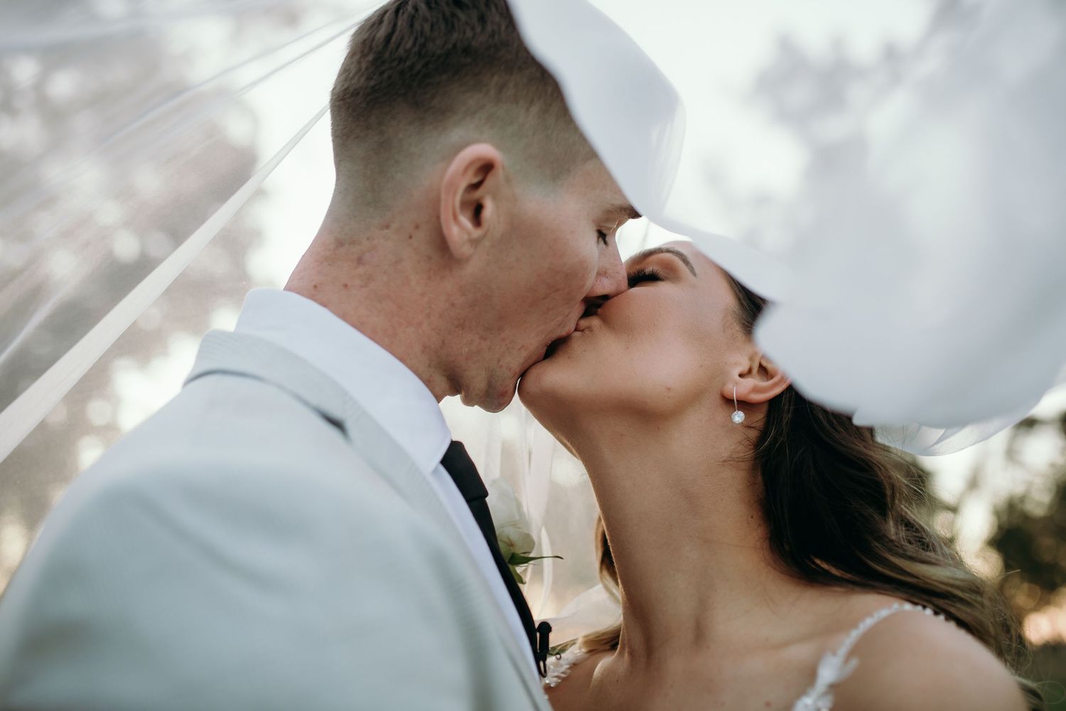 Romantic wedding couple shares intimate moments at sunset.