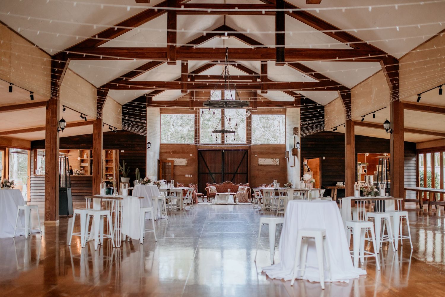 Rustic indoor wedding venue with exposed wooden beams and white decor. Gordon Country, Goomburra.