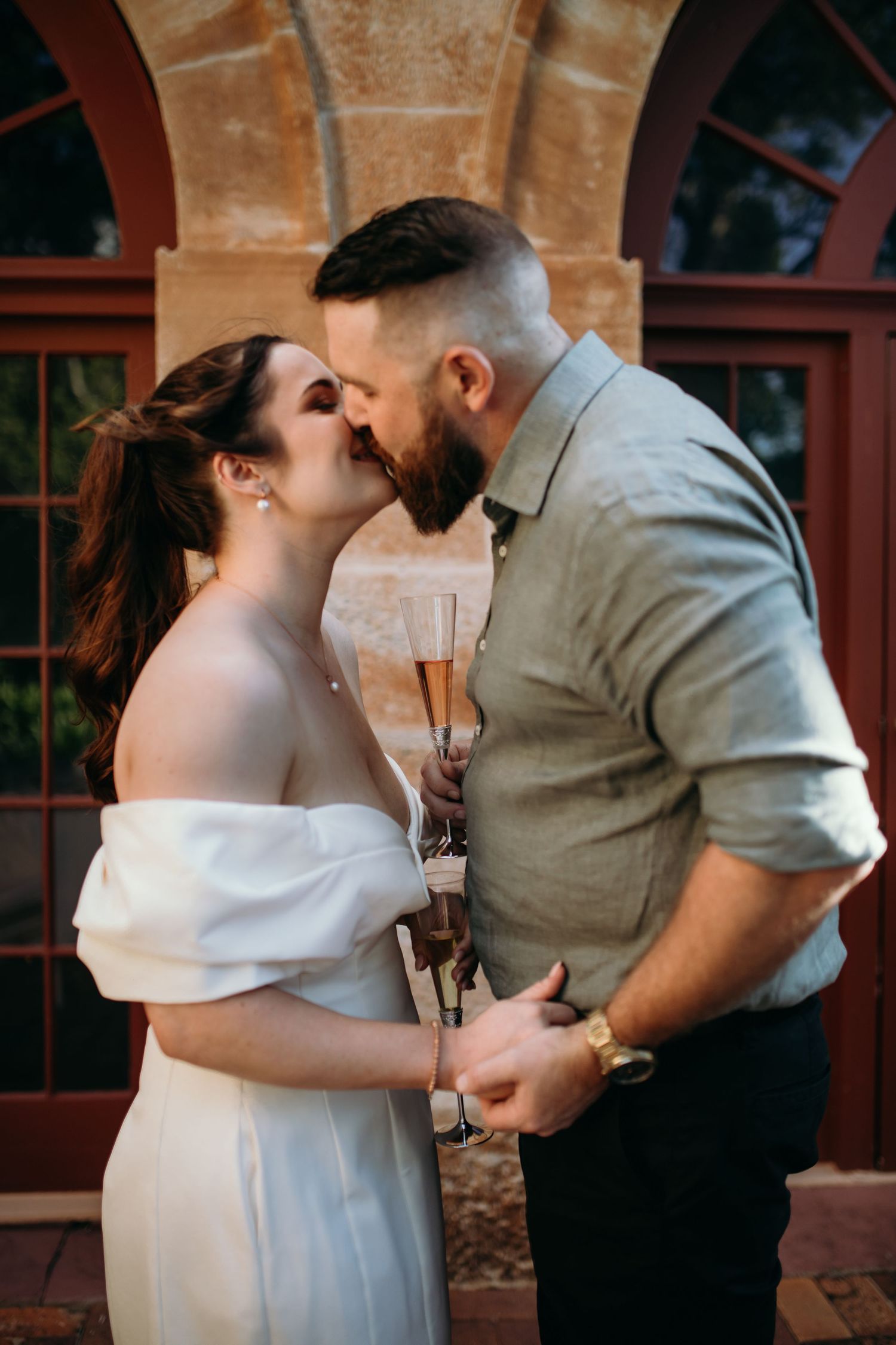 Intimate wedding portraits captured against rustic brick walls with natural lighting.