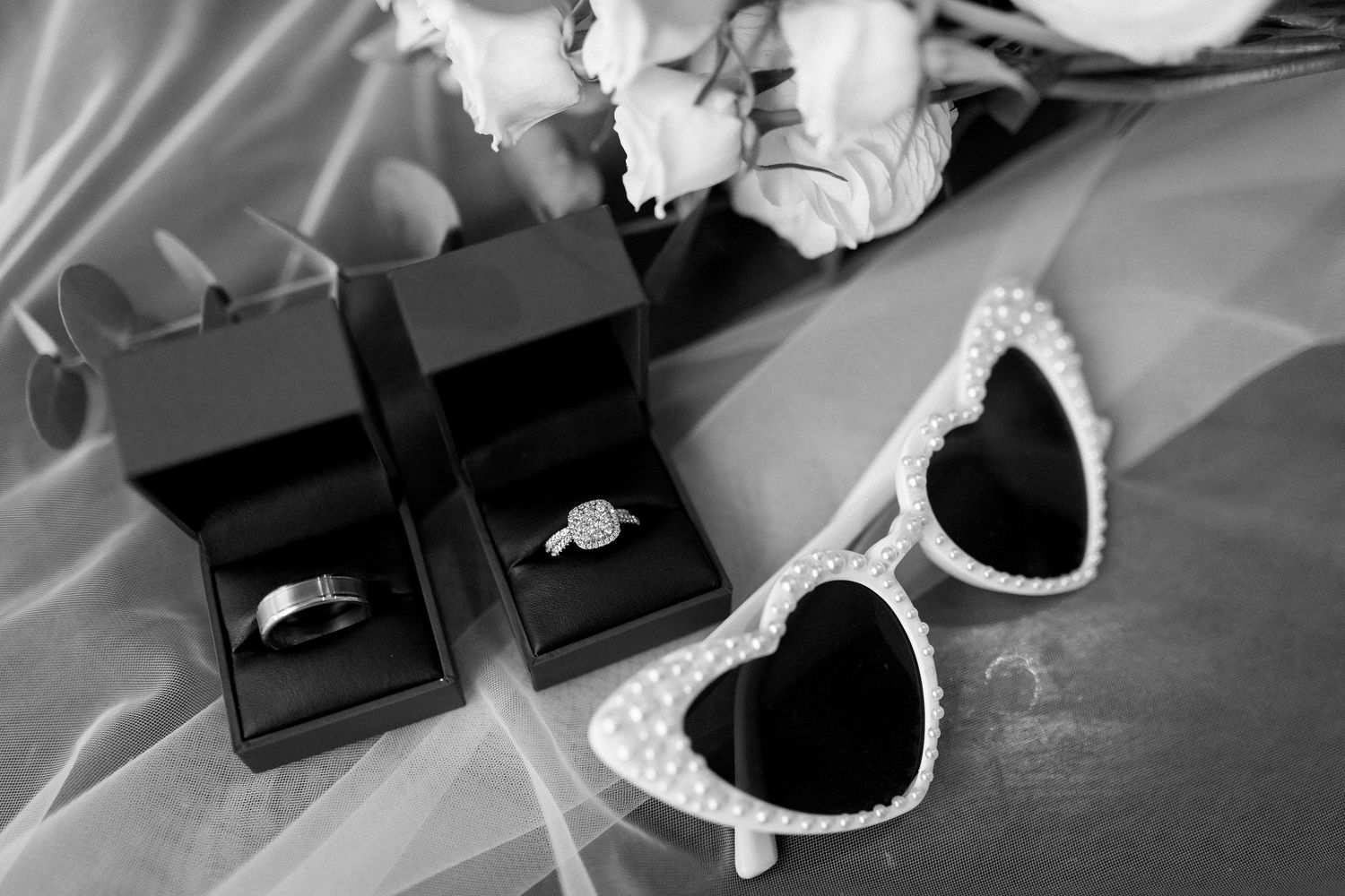 Wedding accessories including jewelry and decorative items arranged on a dark surface.