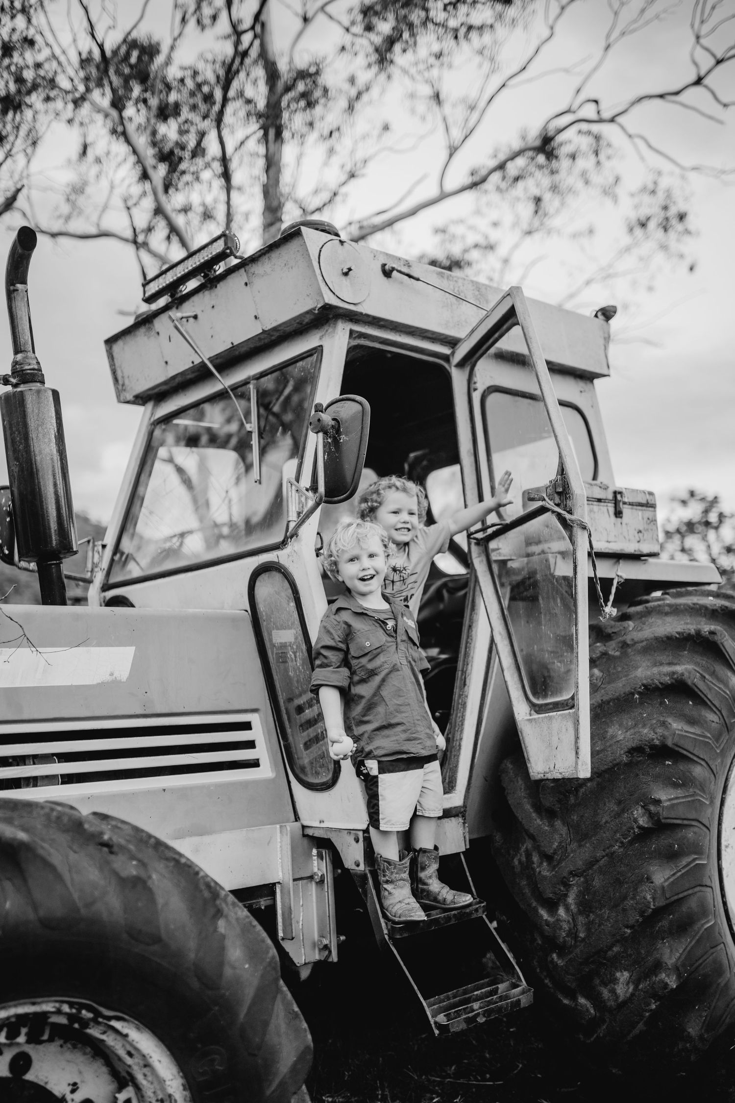 View of someone sitting in the cab of a large farm tractor.