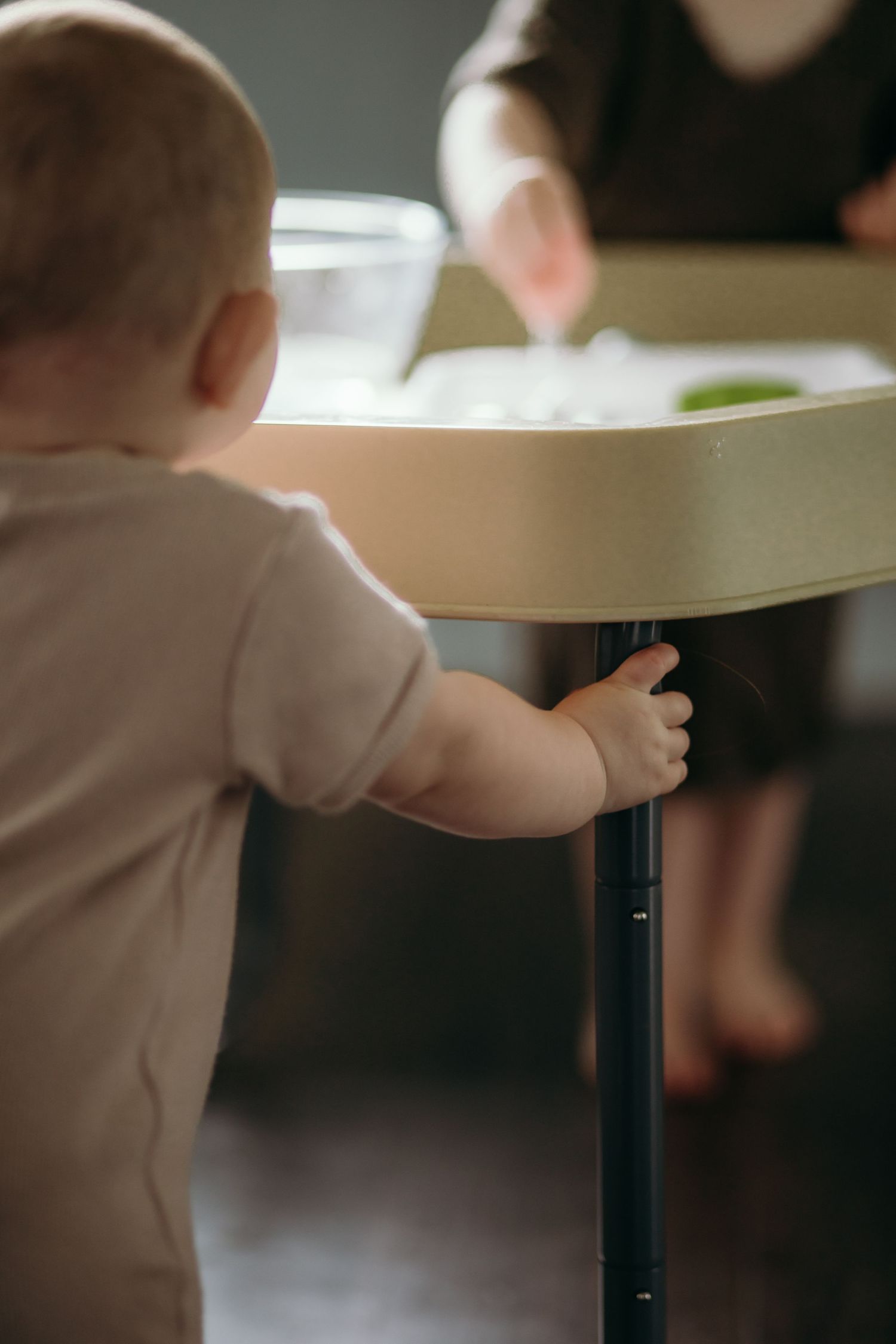 Multiple angles of a toddler reaching up to touch a white table surface.