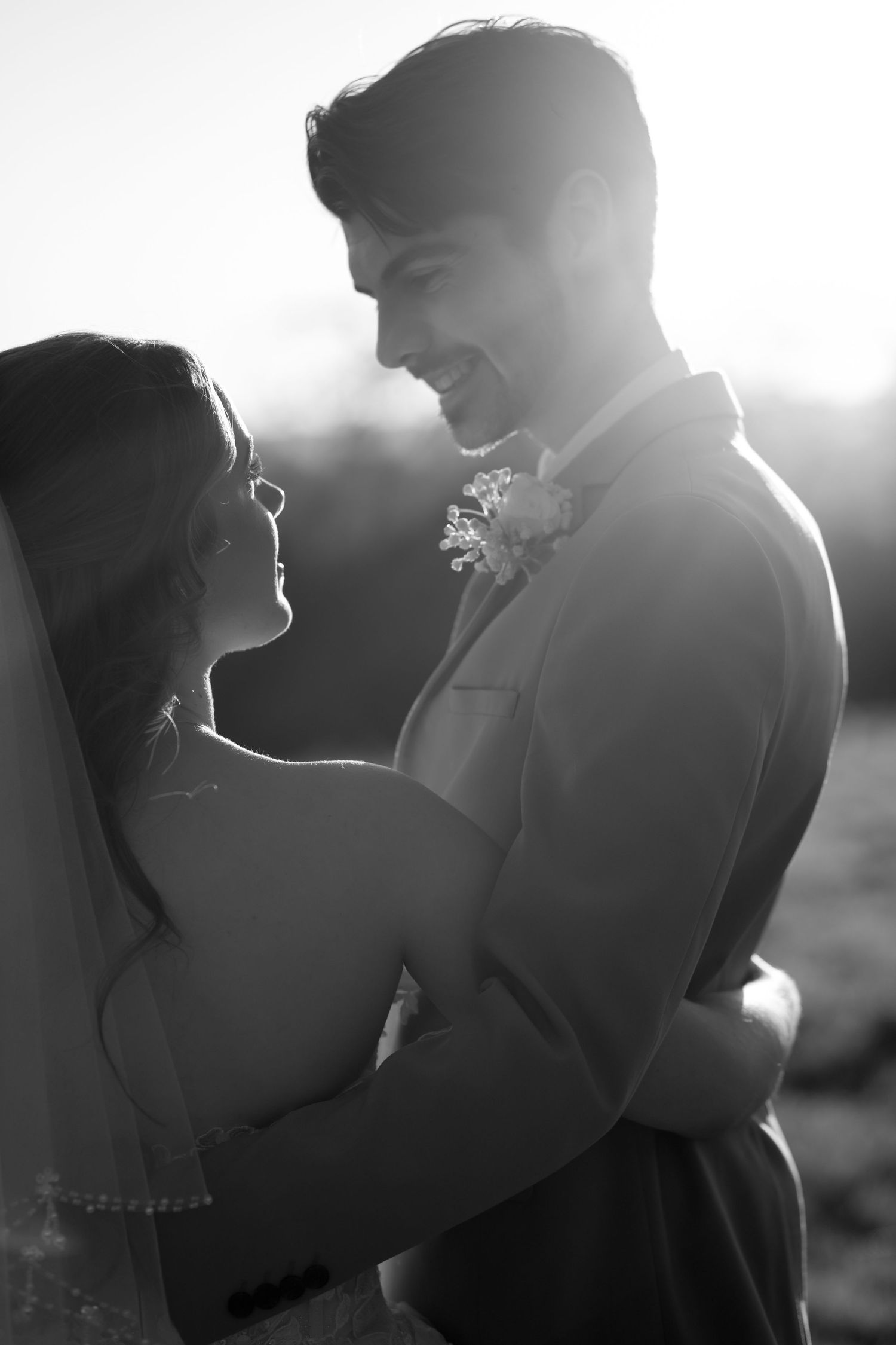 Backlit silhouette of wedding couple sharing an intimate moment.