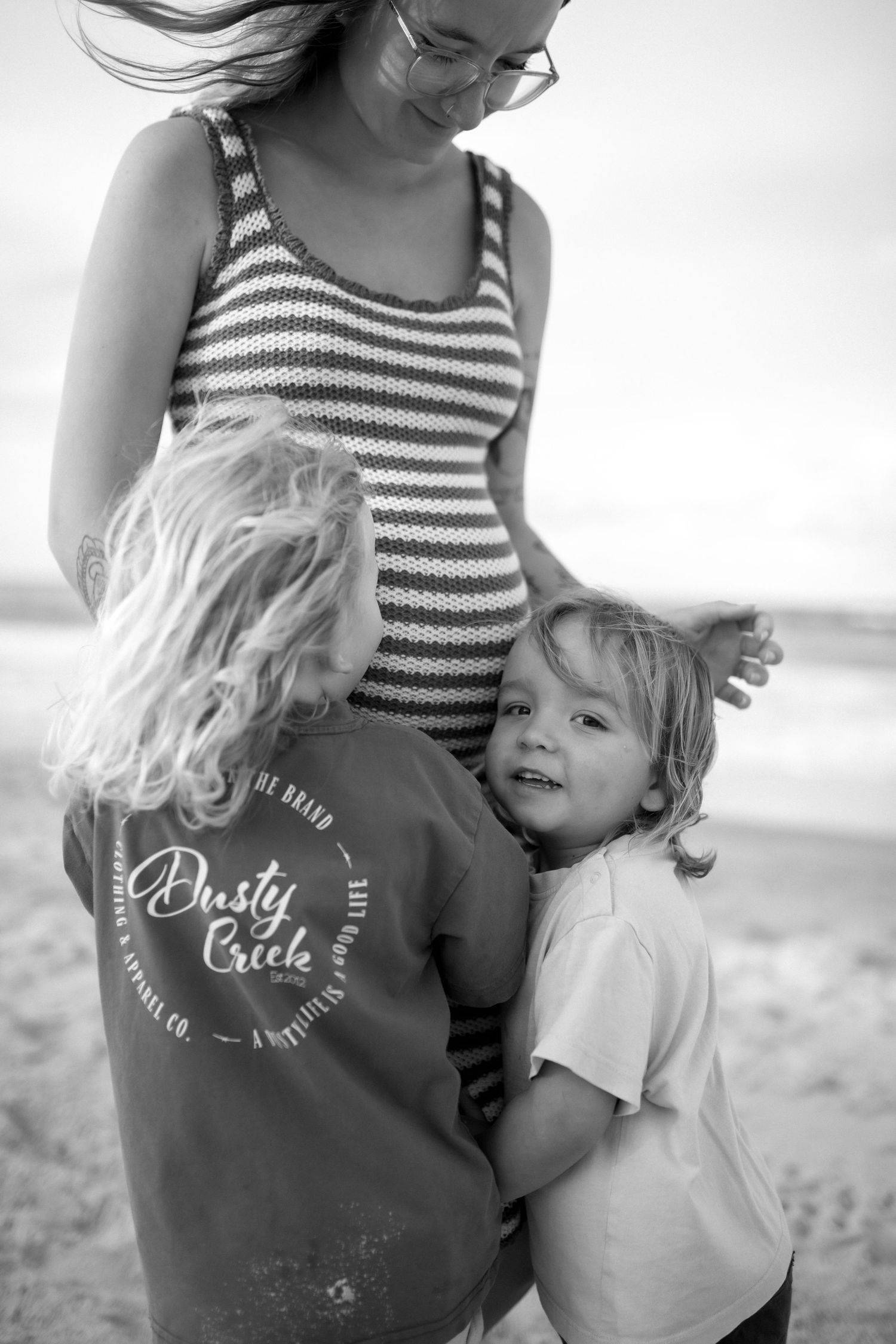 Black and white beach portrait showing striped swimsuits and casual summer moments.