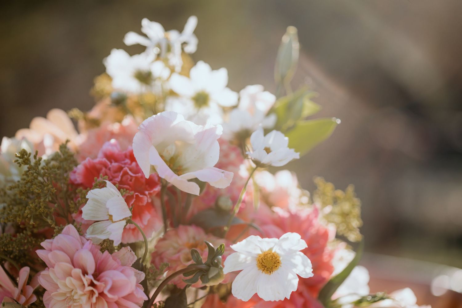 White daisies and pink flowers arranged in a romantic wedding centerpiece.