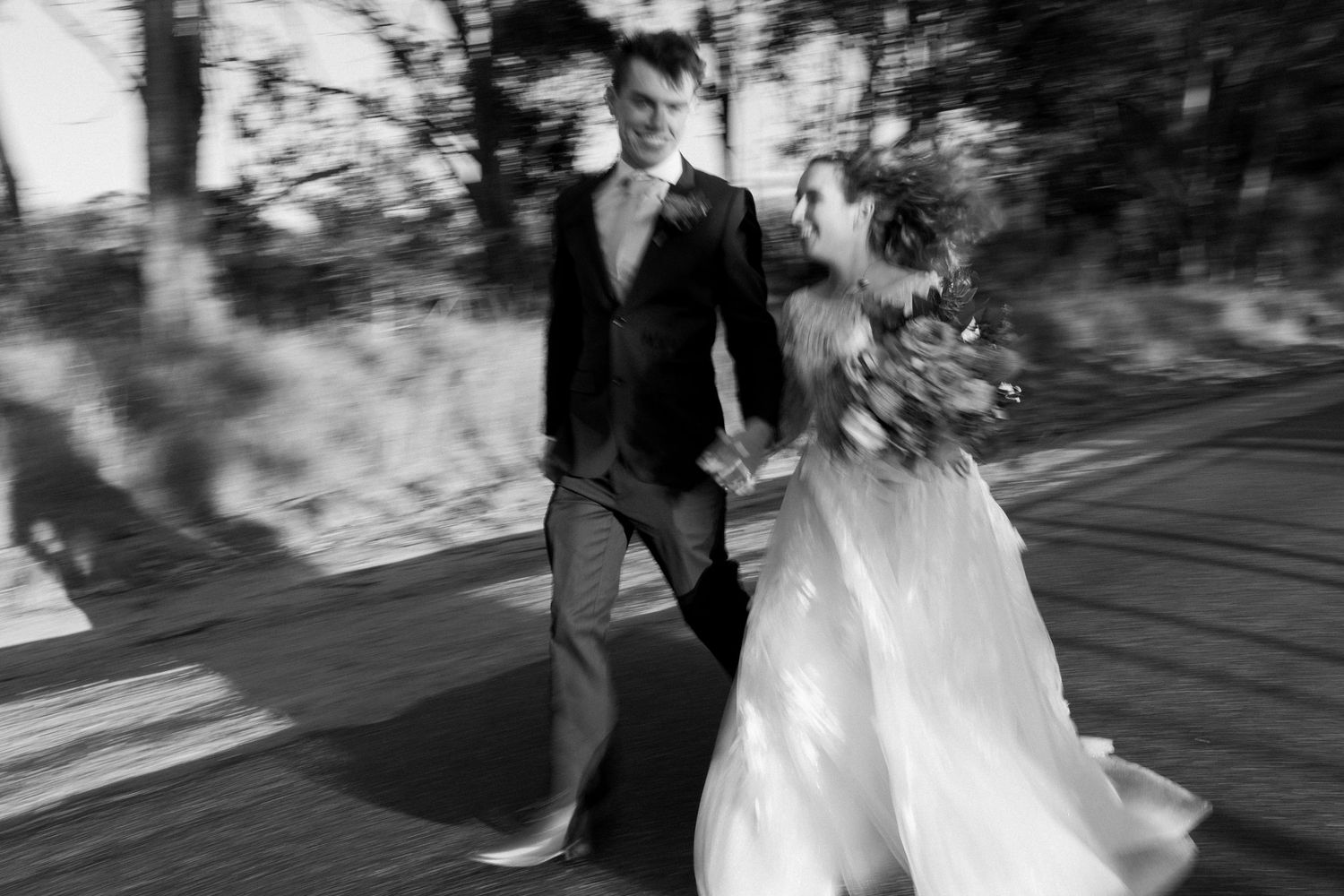 Wedding couple walking along an outdoor path in dramatic lighting.