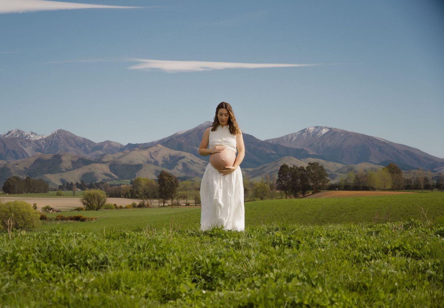 maternity session in clover field with moutains in the back