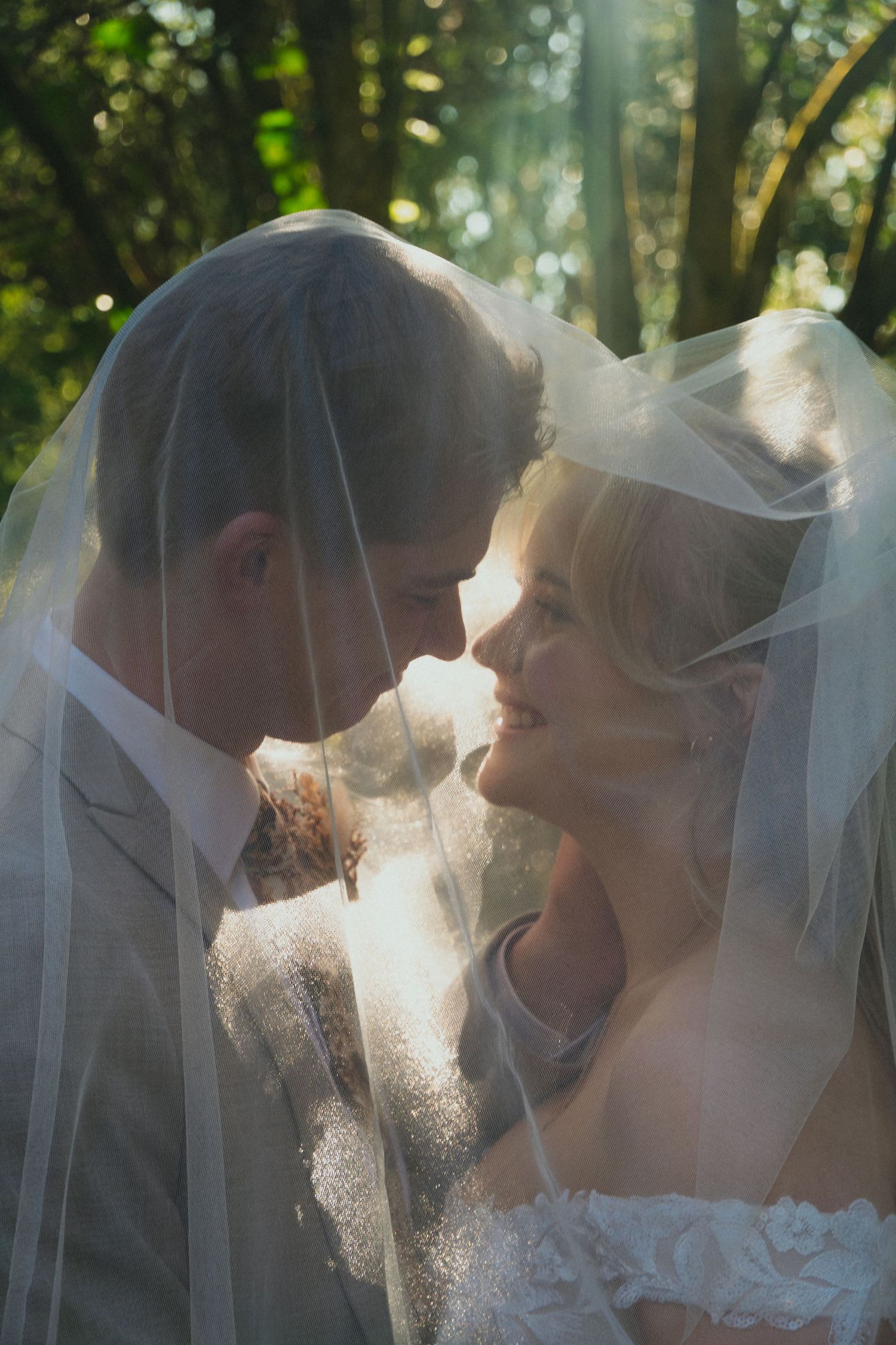 bride and groom in natural light under bride's veil