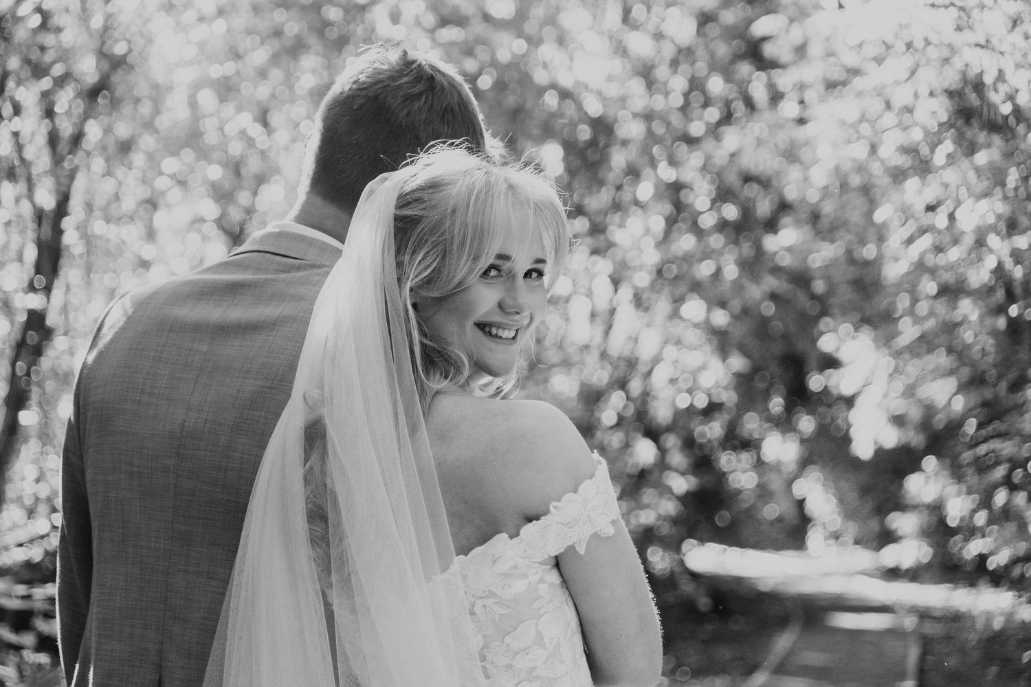 Bride and groom with bride looking back smiling