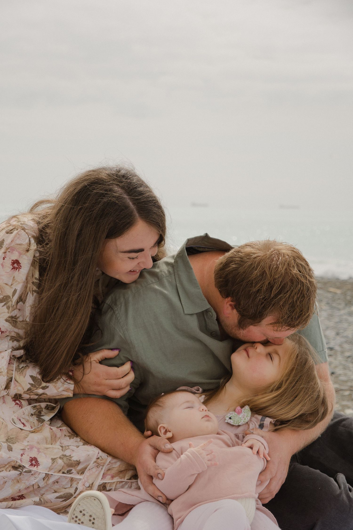 family photo, parent and kids cuddling on beach