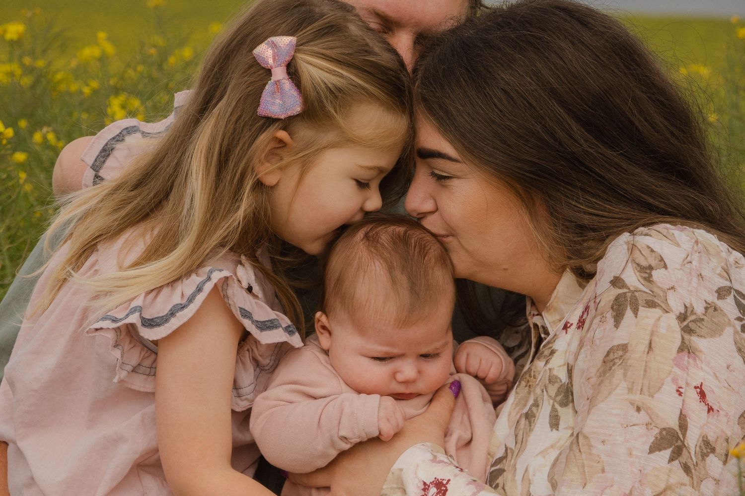 mother and daughter kissing new addition to family