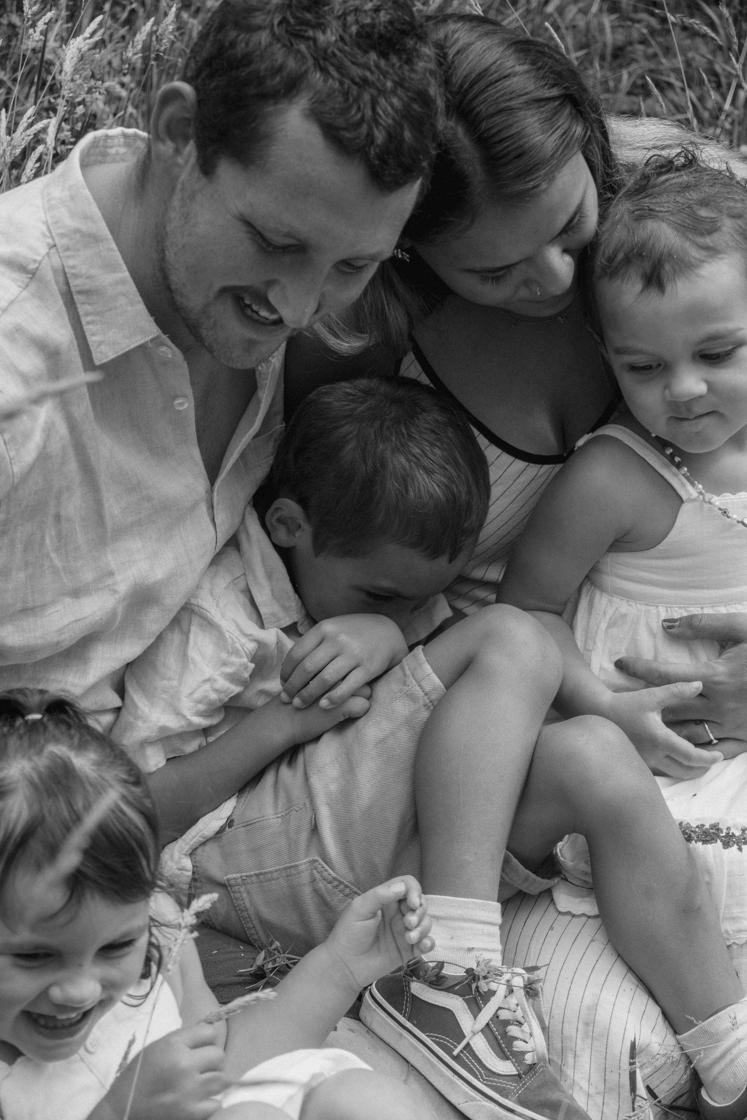 black and white family photo, parent and kids cuddling