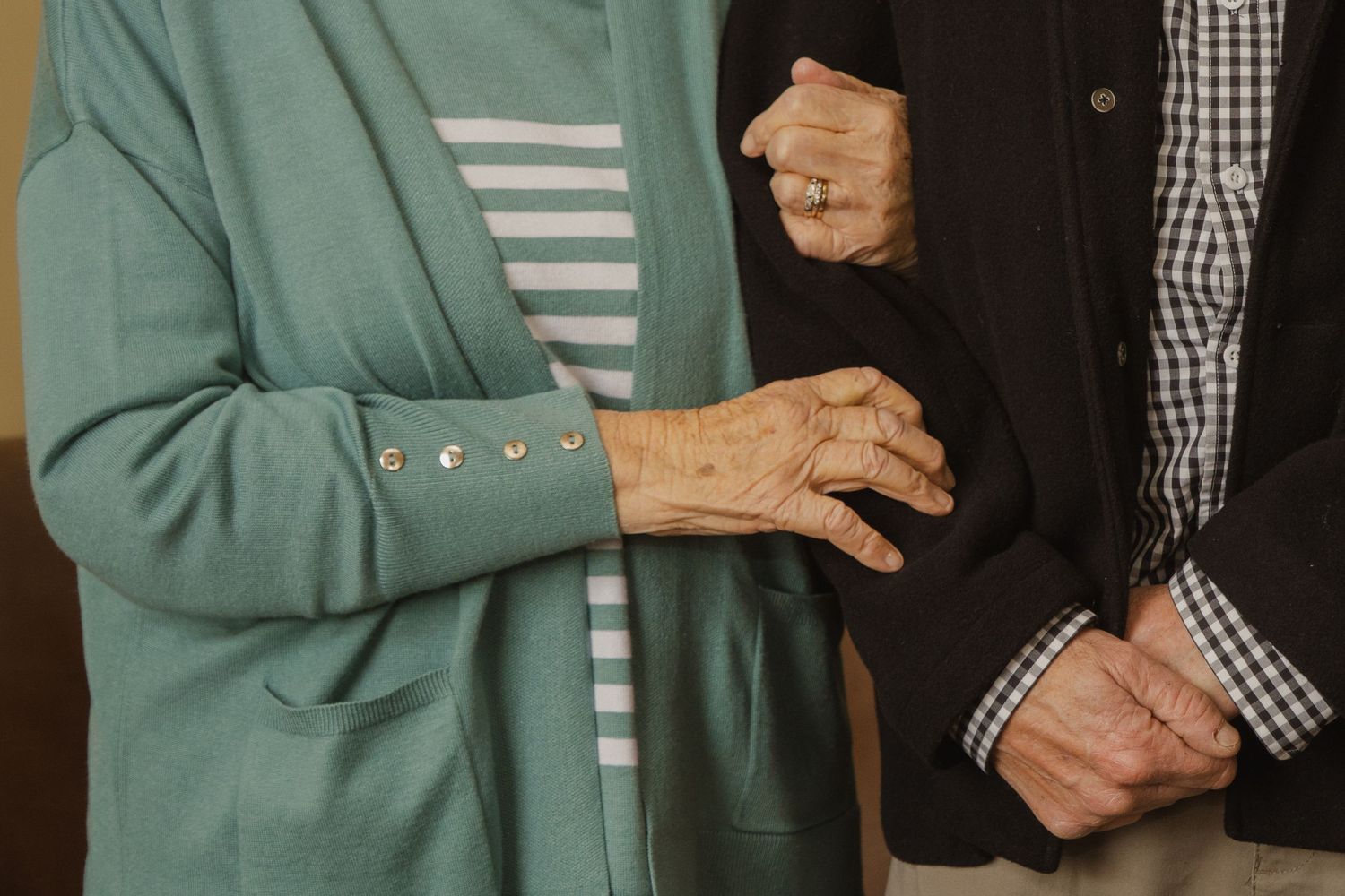elderly couple holding each others arms