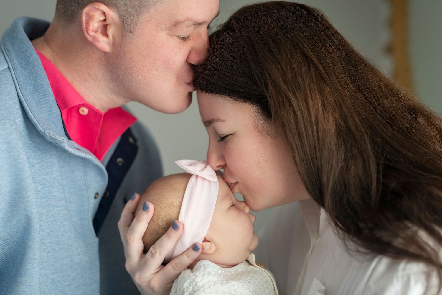 Intimate family moment with new baby being held close.