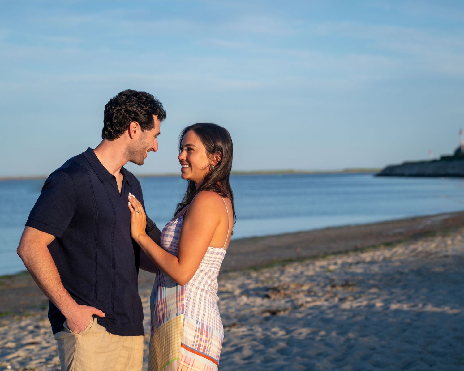 Couple sharing a romantic moment together on a scenic beach at sunset.