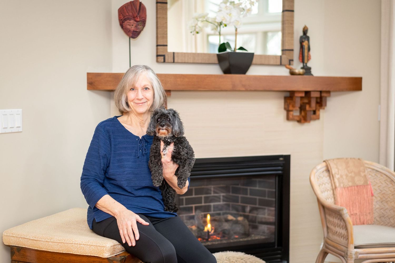 Two dogs and their owners relaxing in a cozy living room with a fireplace.