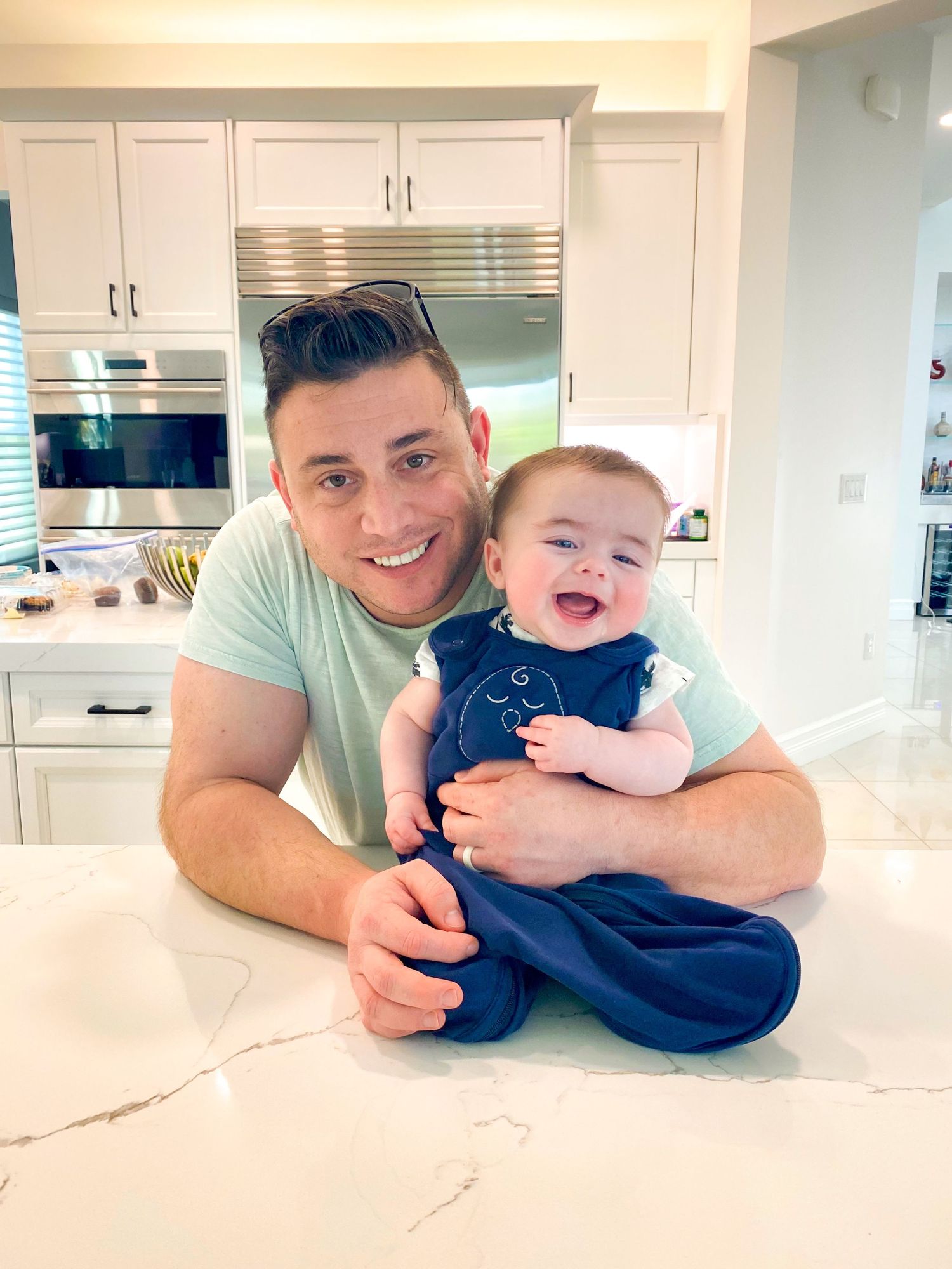 A series of candid photos taken in a bright modern kitchen with white cabinets and marble countertops.