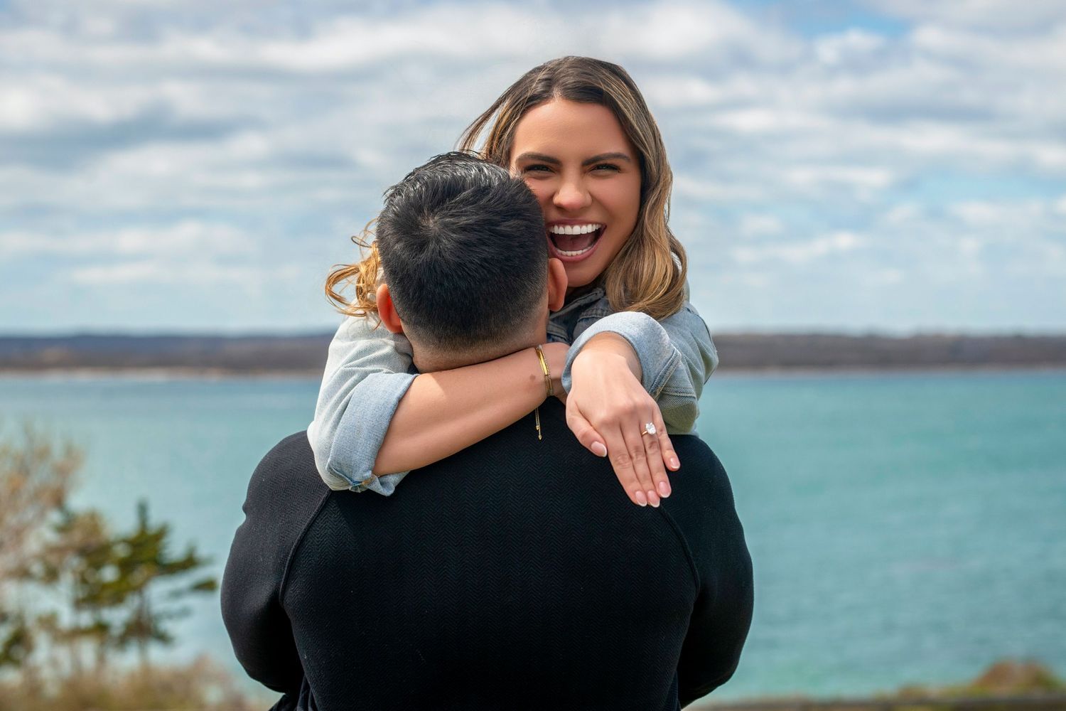 Joyful embraces and celebrations captured against scenic coastal backdrop.
