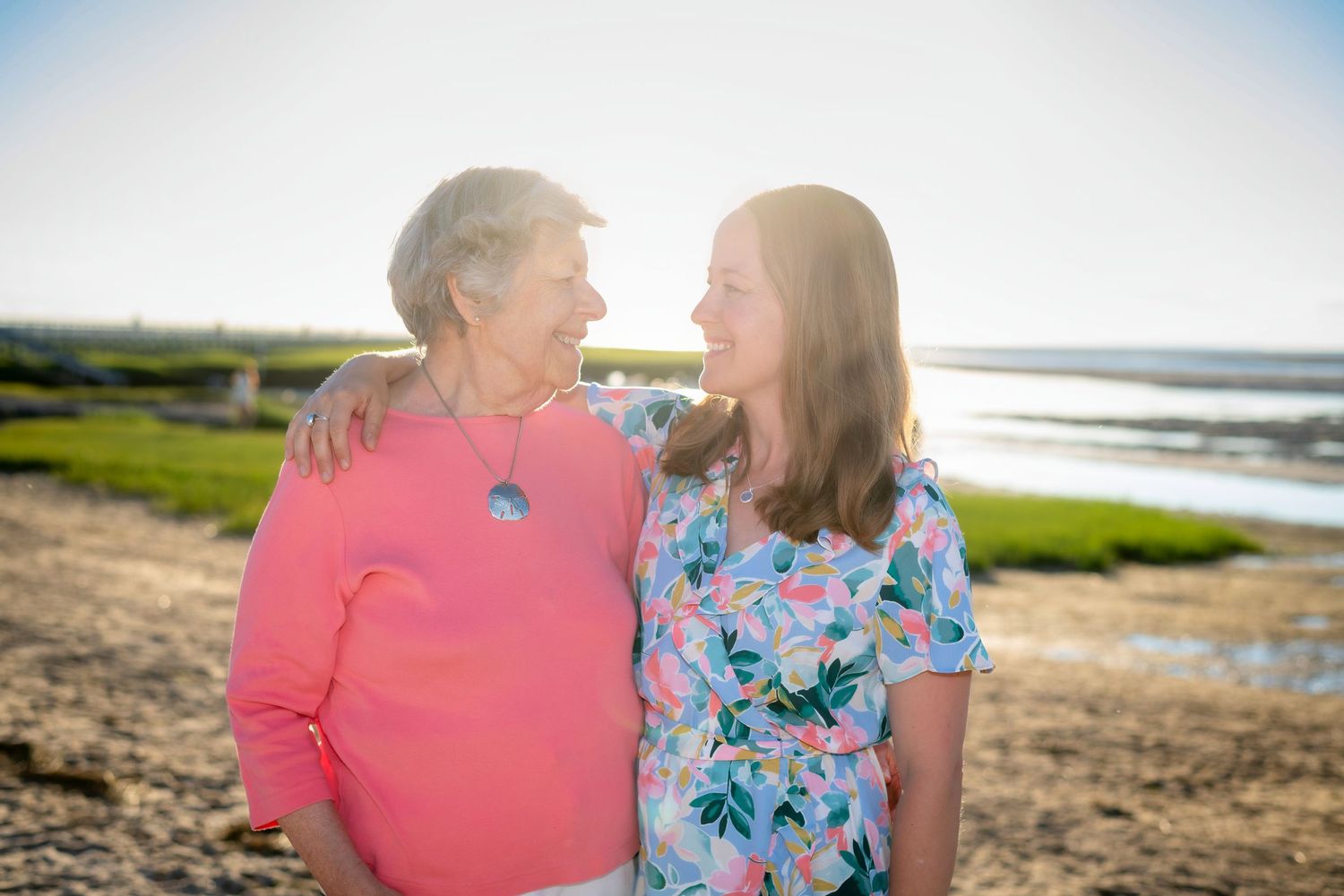 People sharing joyful moments together by the water during golden hour.