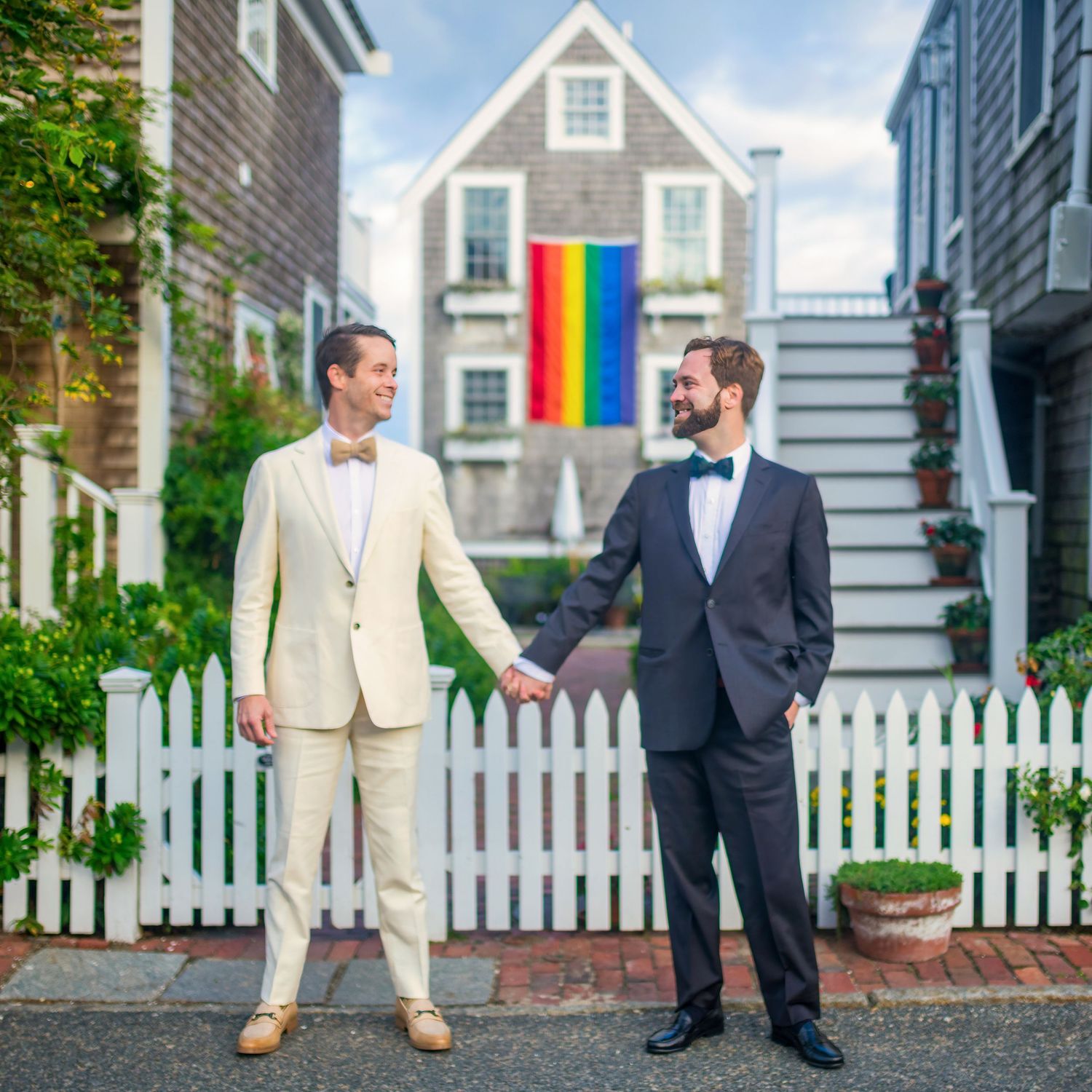 Charming New England street scene with white picket fence and traditional houses.