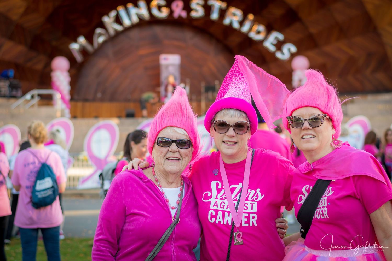 Group wearing matching bright pink shirts gathered for a charity walk or fundraising event.