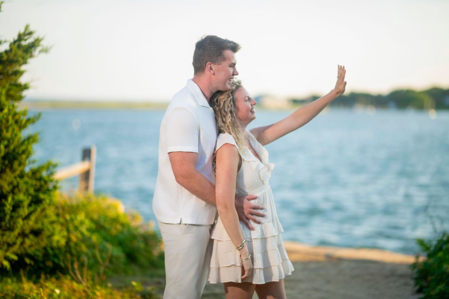 A couple shares joyful moments together during a beach photoshoot at golden hour.