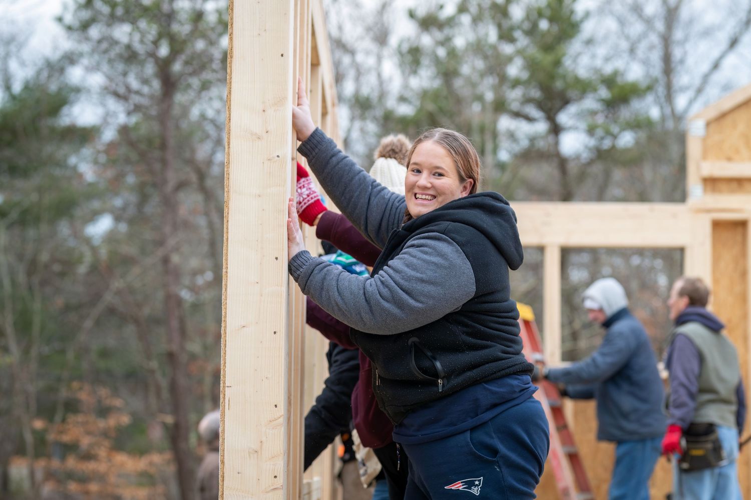Construction or building activity showing wooden framework being assembled outdoors.