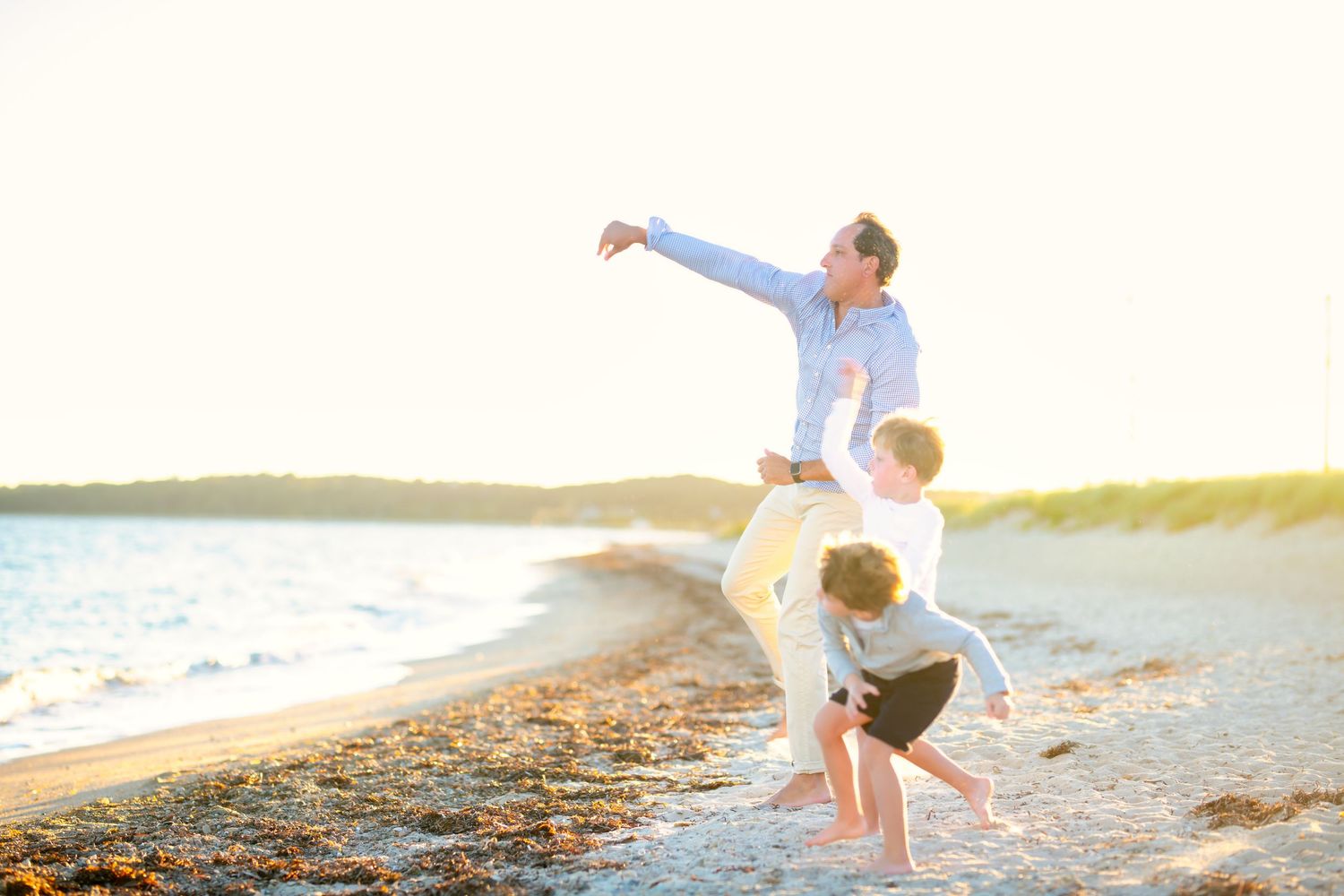 Couple enjoying a romantic sunset walk along a sandy beach with ocean waves in the background.
