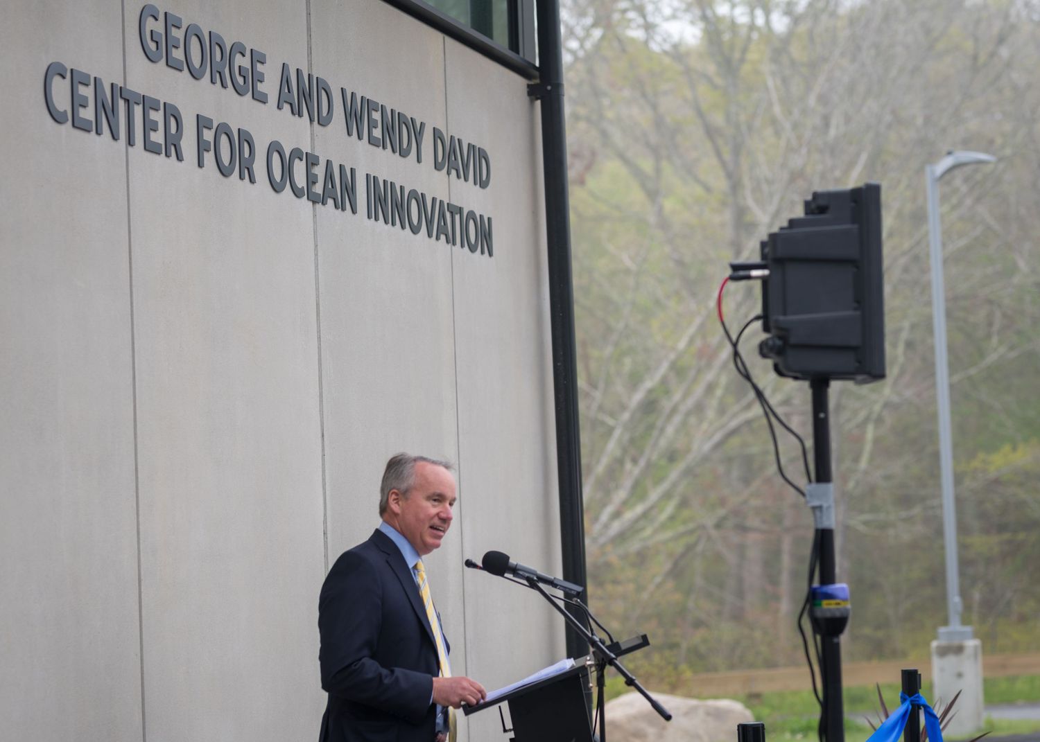 Speaker presenting at podium during event at Ocean Innovation Center.