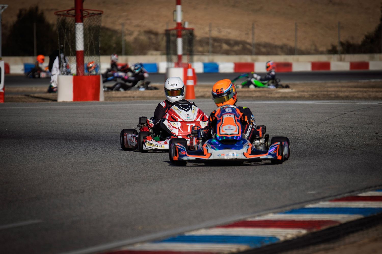 Go-karts maneuvering through a challenging corner on a professional karting circuit.
