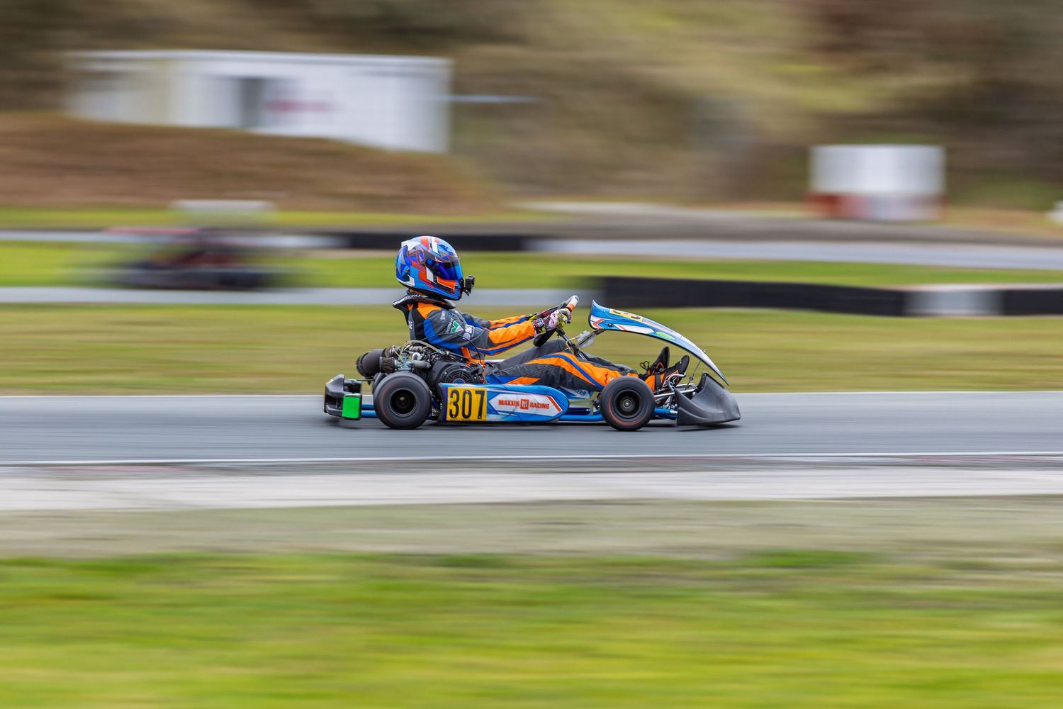 Motorcycle sidecar racing teams lean into turns at high speeds on a racetrack during competition.
