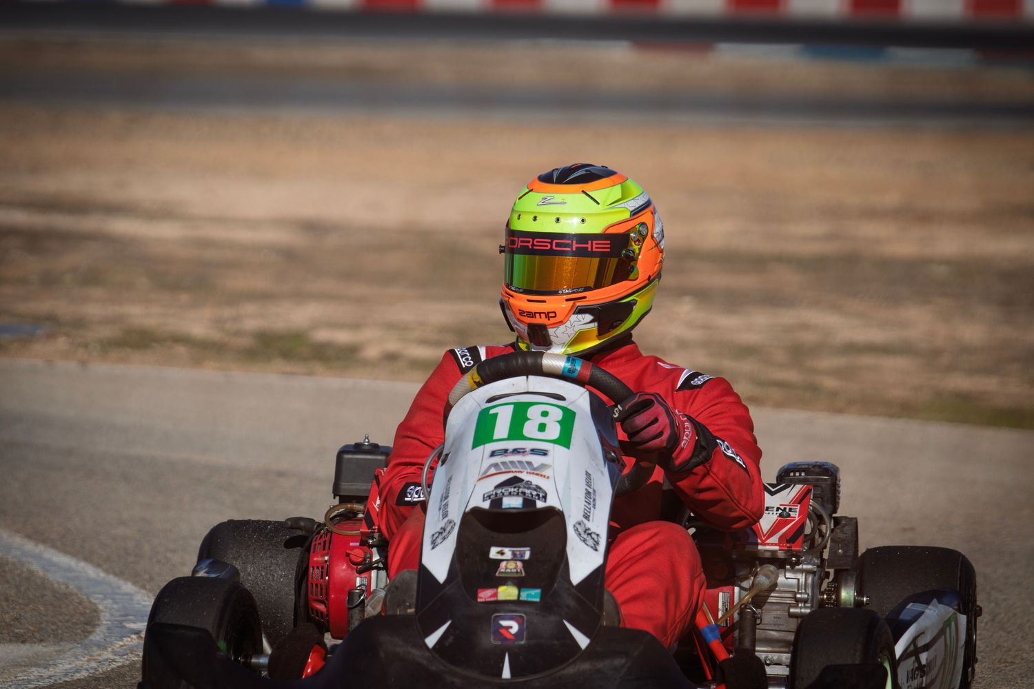 Go-kart racers navigating a track turn during a competitive race.