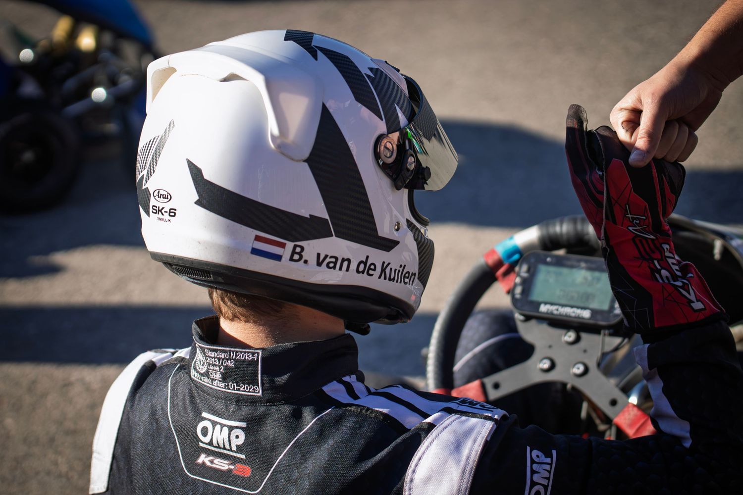 Racing helmet with OMP branding shown in close-up detail.