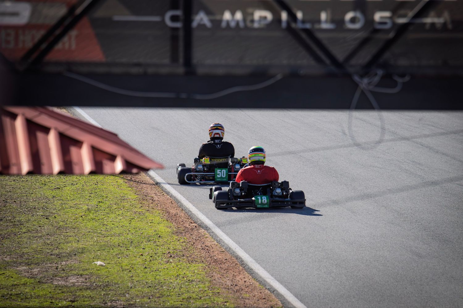 Two go-karts competing for position on a winding karting track.